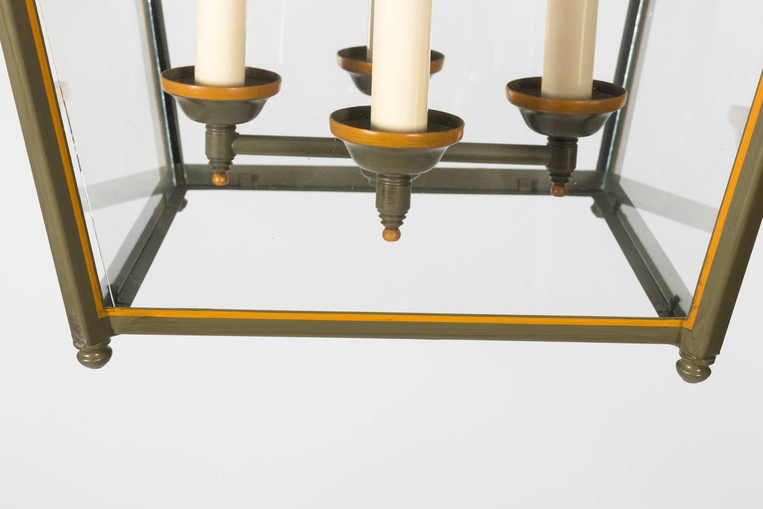 Contemporary tole green painted square lantern with gold trim and four lights.
 