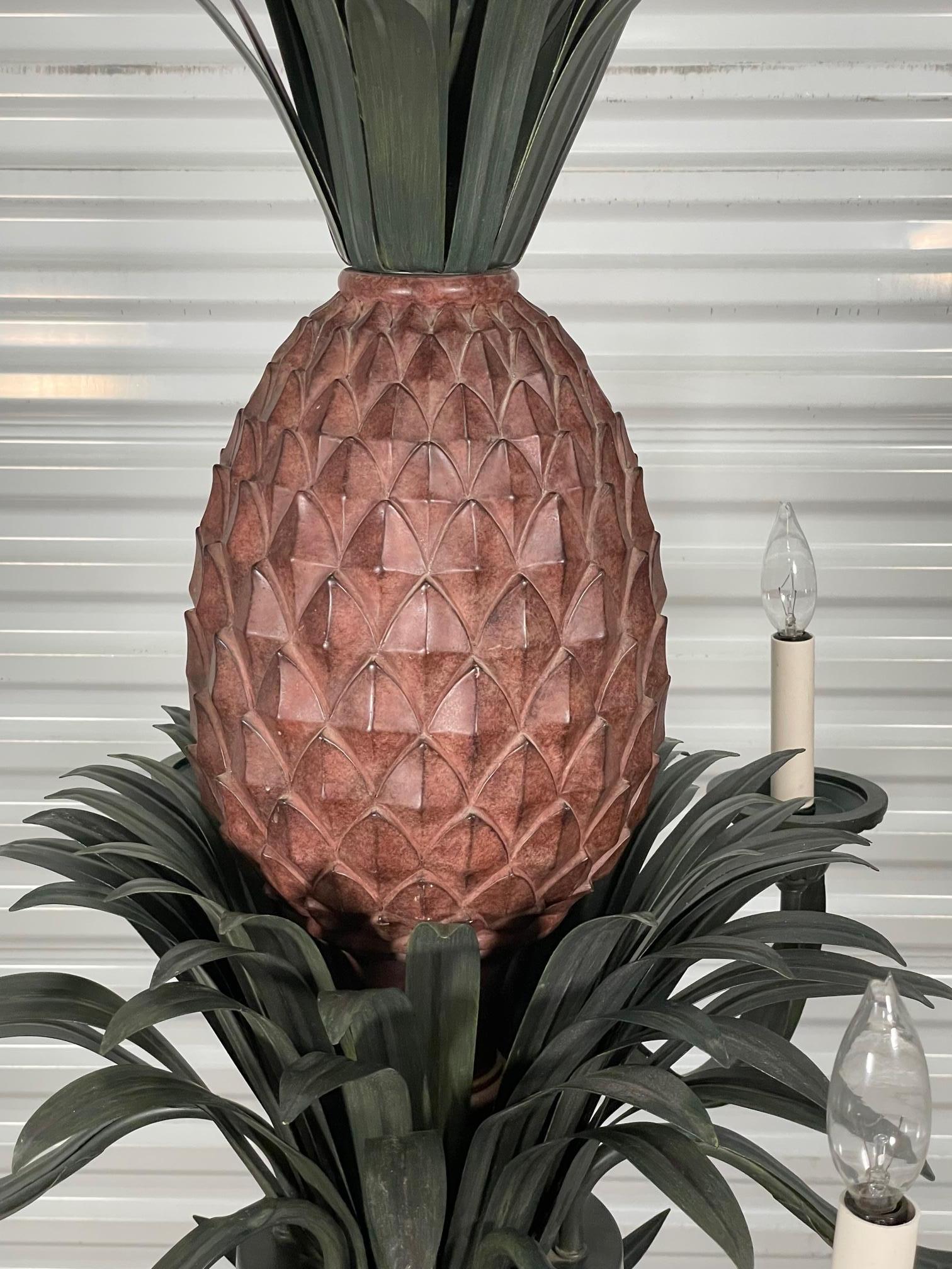 Large 6-arm chandelier features a sculptural pineapple center with tole metal fronds above and below. Good condition with minor imperfections. We have two of these, enquire if interested.

 