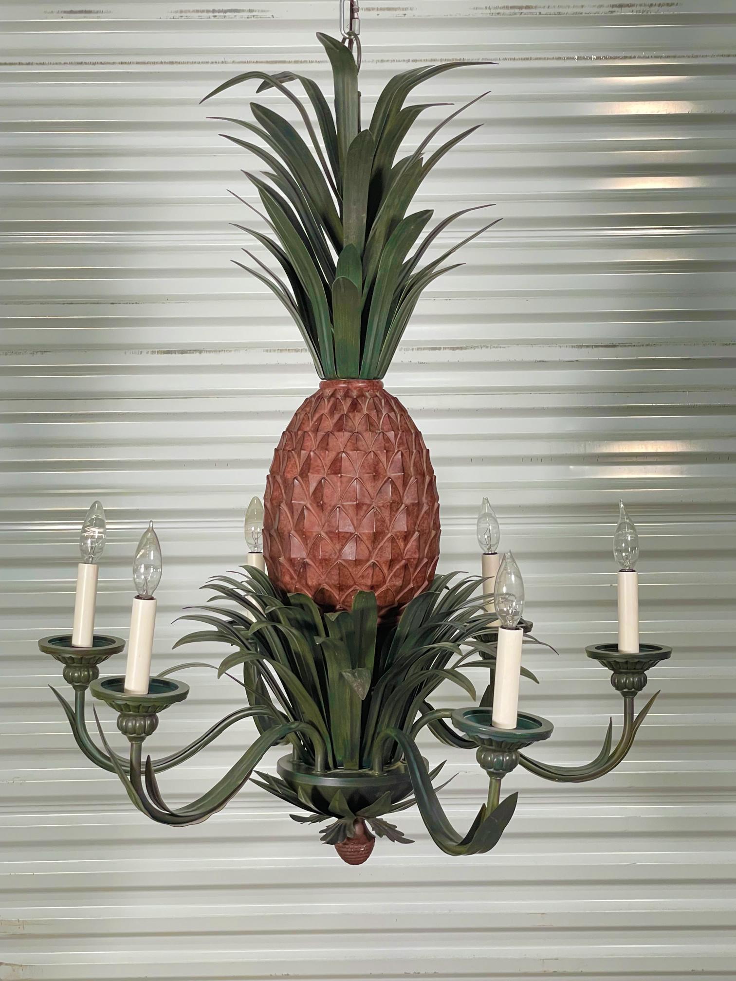 Large 6-arm chandelier features a sculptural pineapple center with tole metal fronds above and below. Good condition with imperfections consistent with age, see photos for condition details. We have two of these in stock, inquire if interested.
For