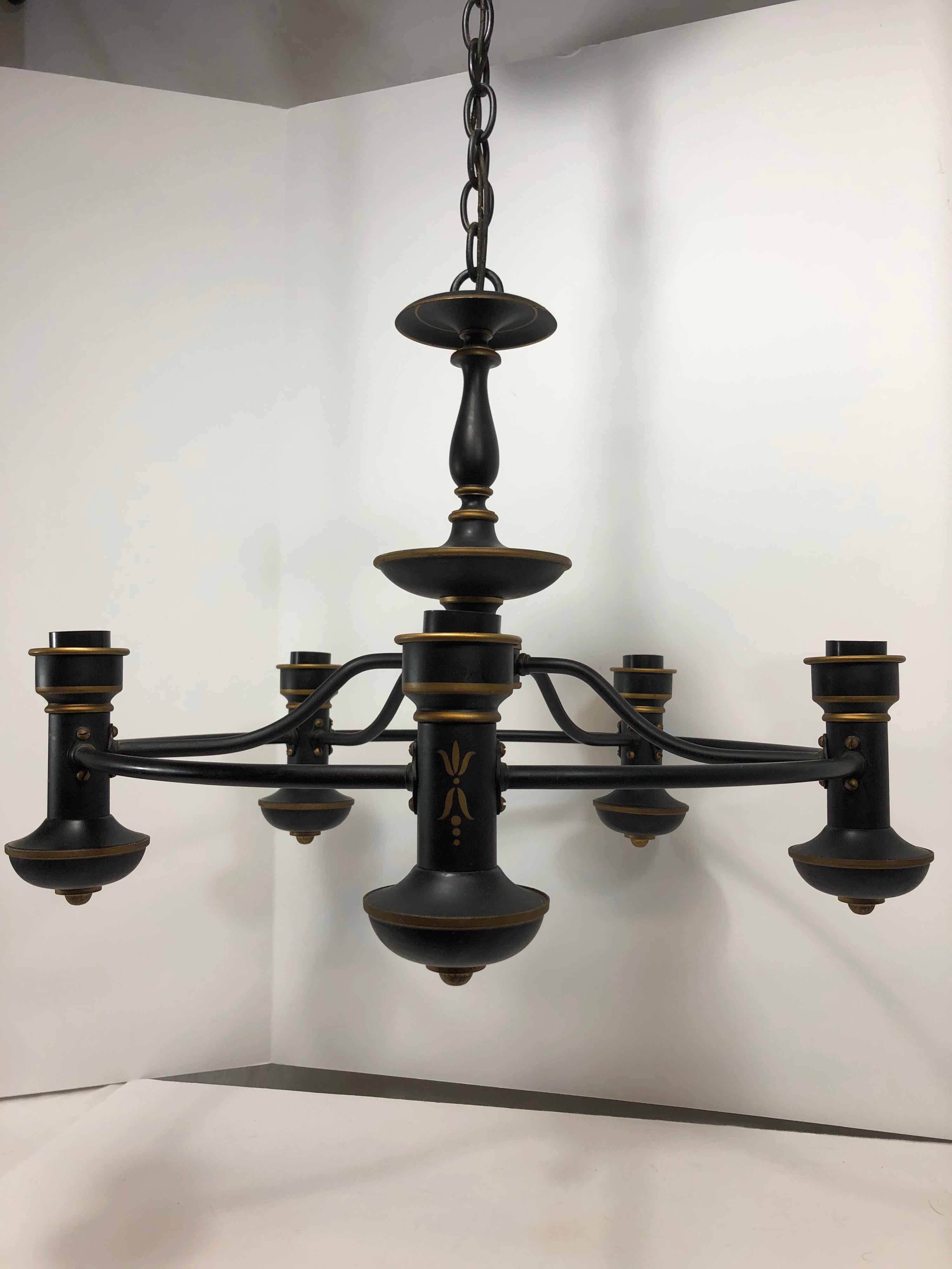Tole painted metal chandelier in black and gold. Five arms, with original ceiling cap. Working condition.