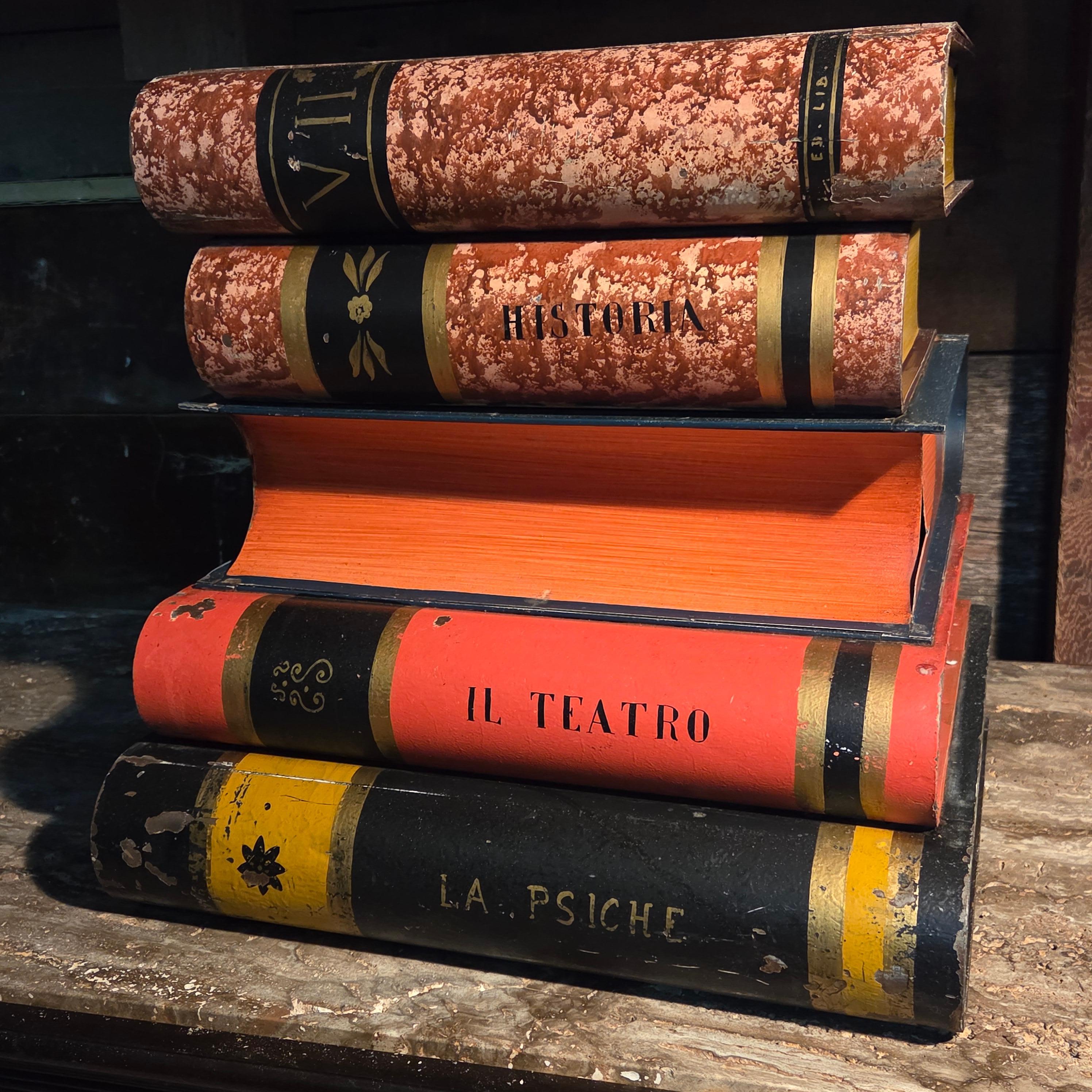 This rare and whimsical Italian end table, crafted in the 1940s–50s, takes the imaginative form of a stack of antique books, rendered in hand-painted tole. With its lively palette of ochre, vermilion, turquoise, and black highlighted by gilt