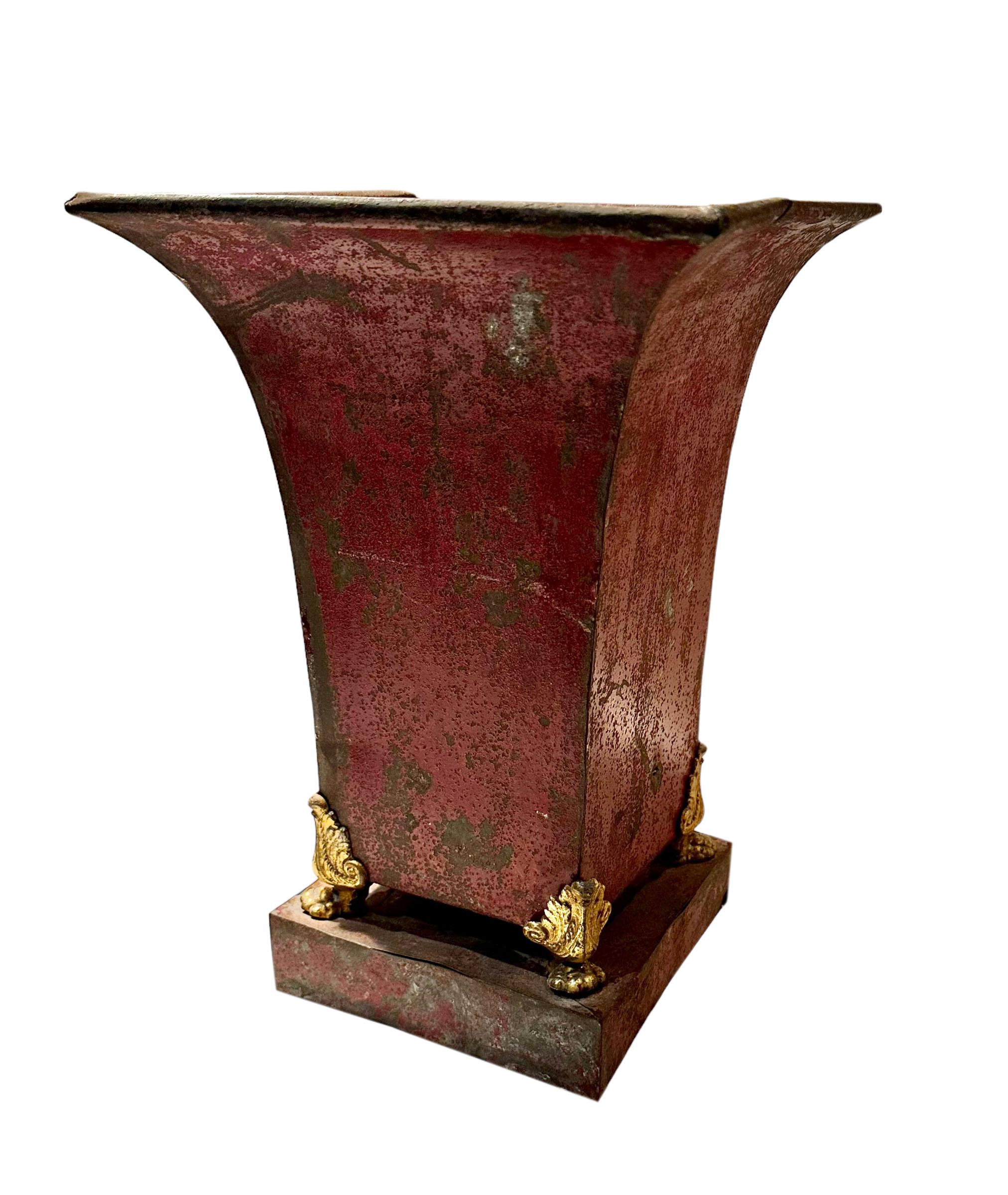 An original red color tole urn with bronze lions feet. Has a lot of patina with some condition issues but looks sensational anyway. The damage does not affect it it has a lot of charm the way it is. Early 19th century, French.