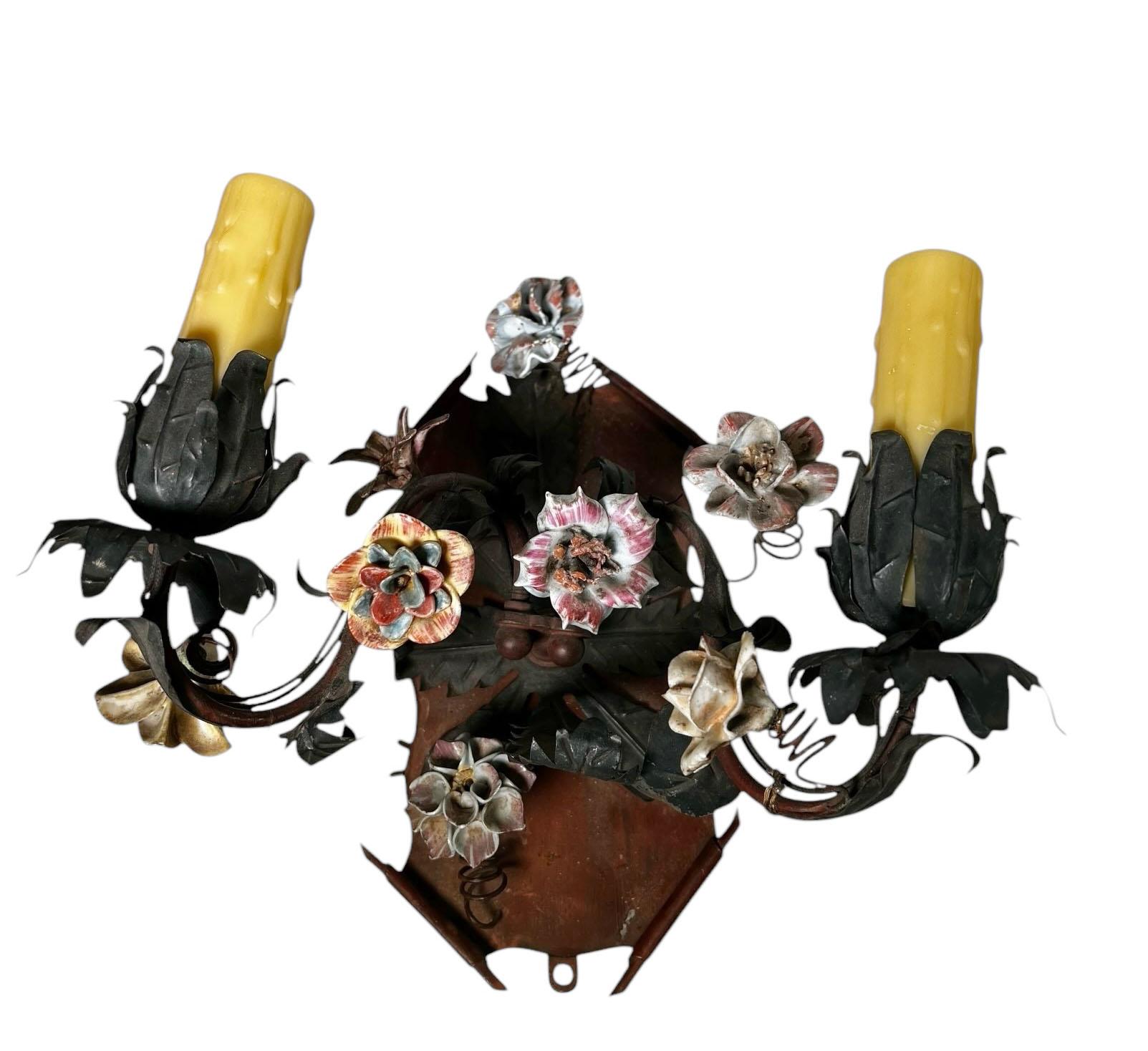 This exquisite pair of antique tole two candle sconcesfeature delicate handcrafted porcelain flowers, adding an elegant and romantic touch. The metal combined with the soft beauty of the porcelain, reflects the timeless artistry of Italian