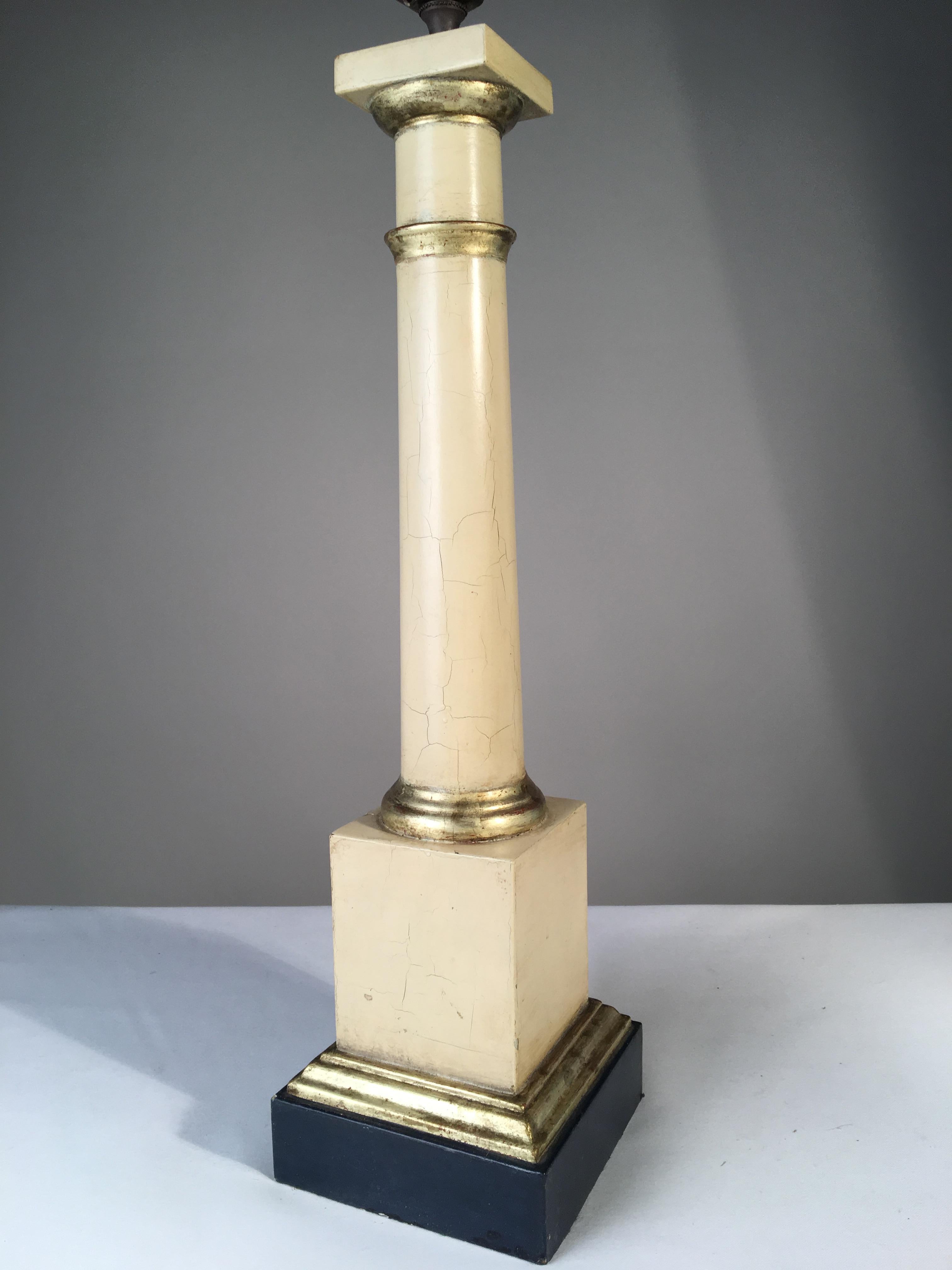 A tole column-form table lamp in the Empire style, cream paint and parcel gilt finish, with dark blue painted base, mid-20th century.