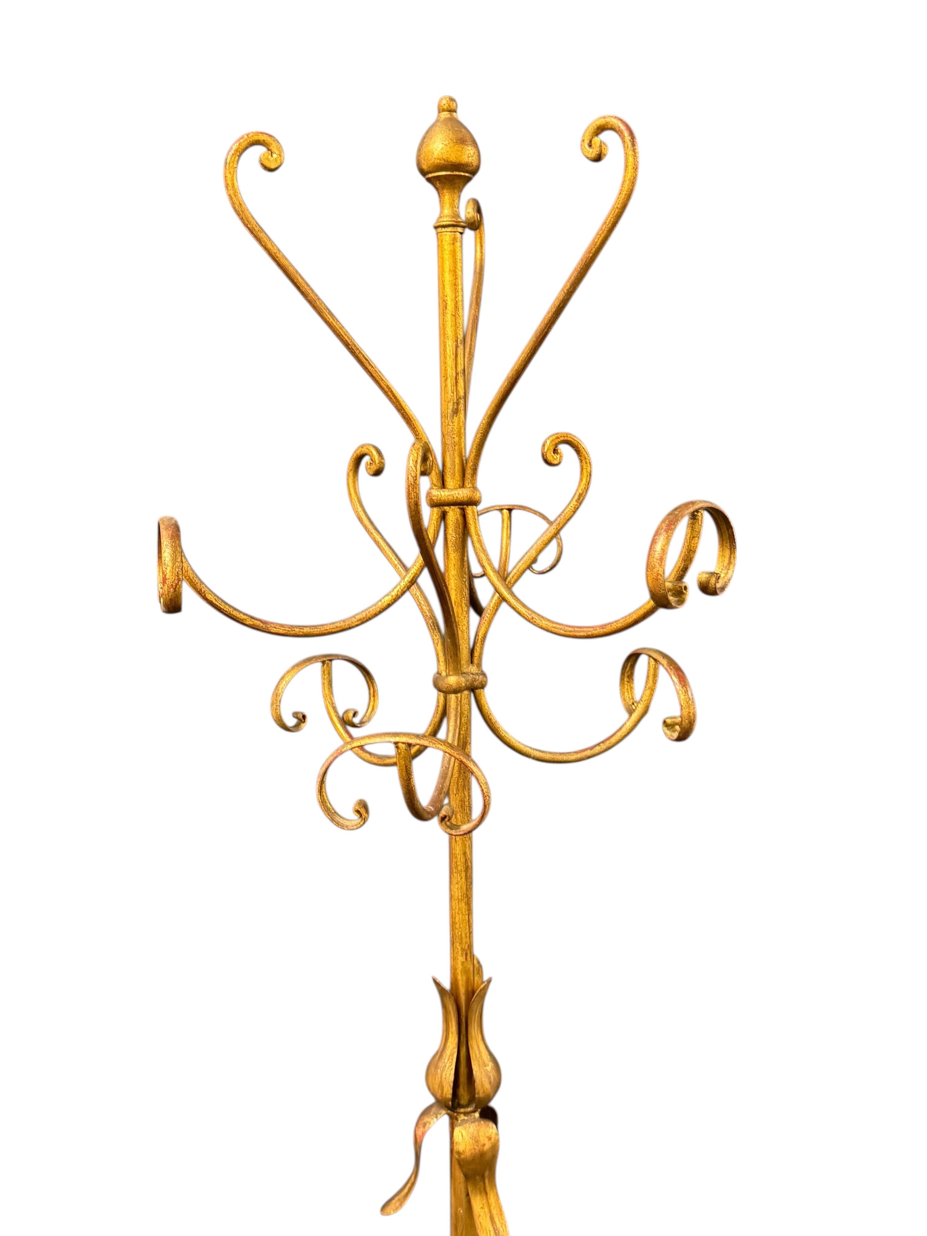 Un bellissimo appendiabiti o cappelliera in ferro battuto dorato della metà del secolo scorso, realizzato intorno agli anni '60 o prima e progettato nello stile di Hans Kögl. Questo pezzo elegante è caratterizzato da una base a treppiede scultorea e