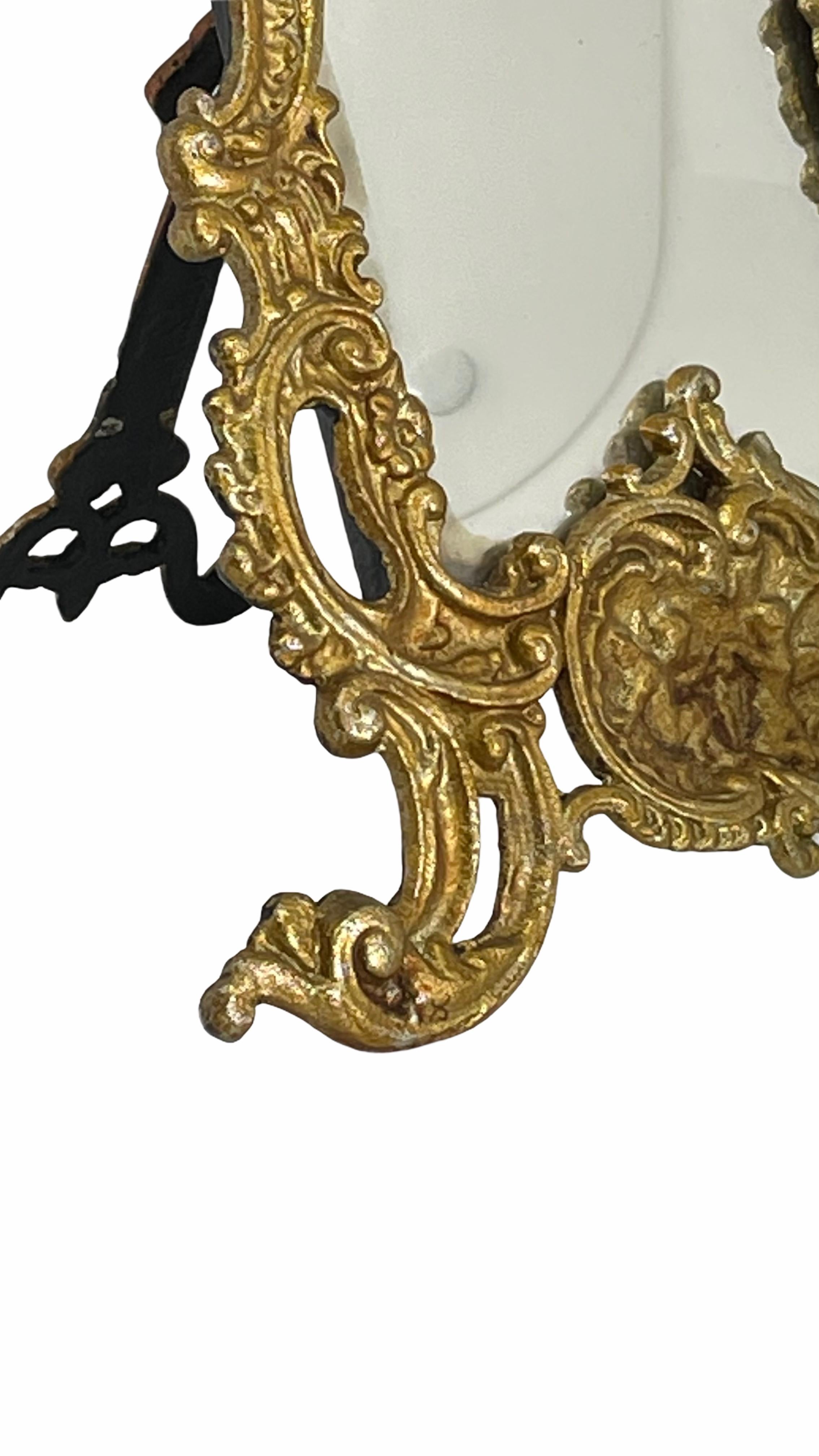 A gorgeous vanity mirror in a gilded metal frame. With minor signs of wear as expected with age and use. Mirror in distressed condition. A nice addition to any boudoir.
