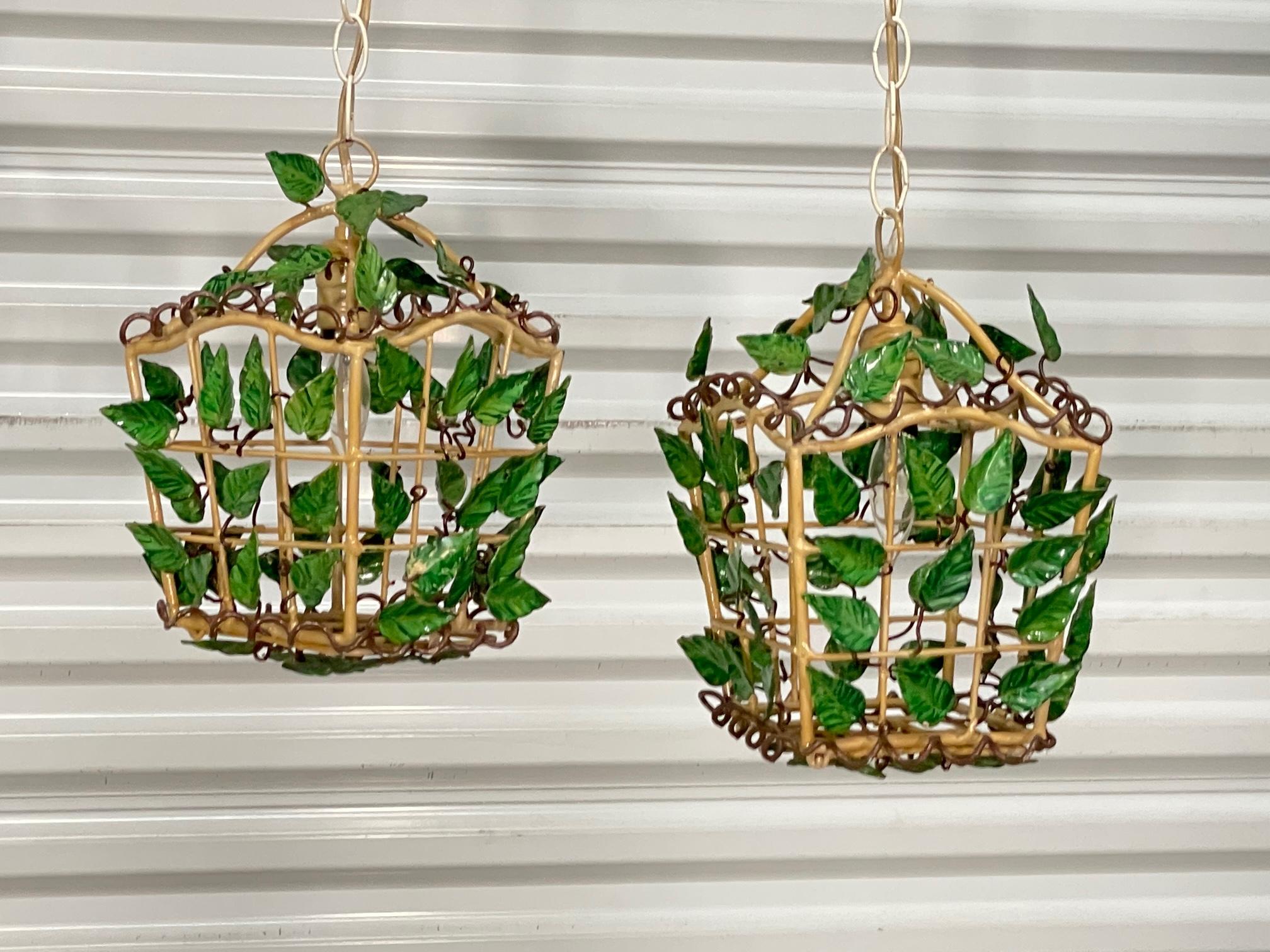 Pair of vintage hand painted pendant lights feature a lantern design with tole vines and leaves throughout. Good condition with imperfections consistent with age (see photos).
 
 