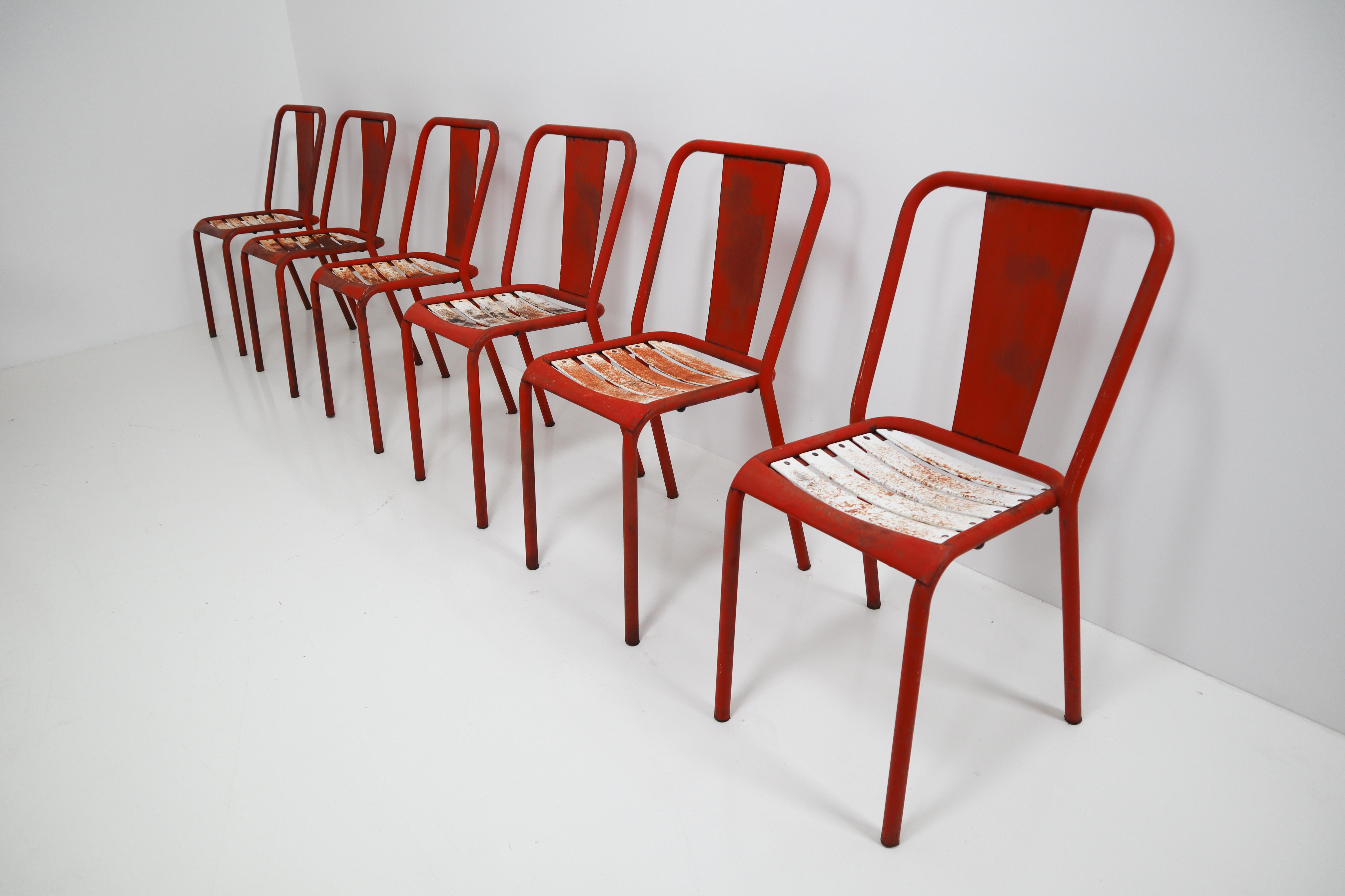 Tolix T4 metal chairs by designer Xavier Pauchard, in red with white color. A lot of patina. Probably from 1950, without certainty. Ideal for midcentury, industrial decoration. Measures: Seat height 45 cm. 

The French company Tolix was founded