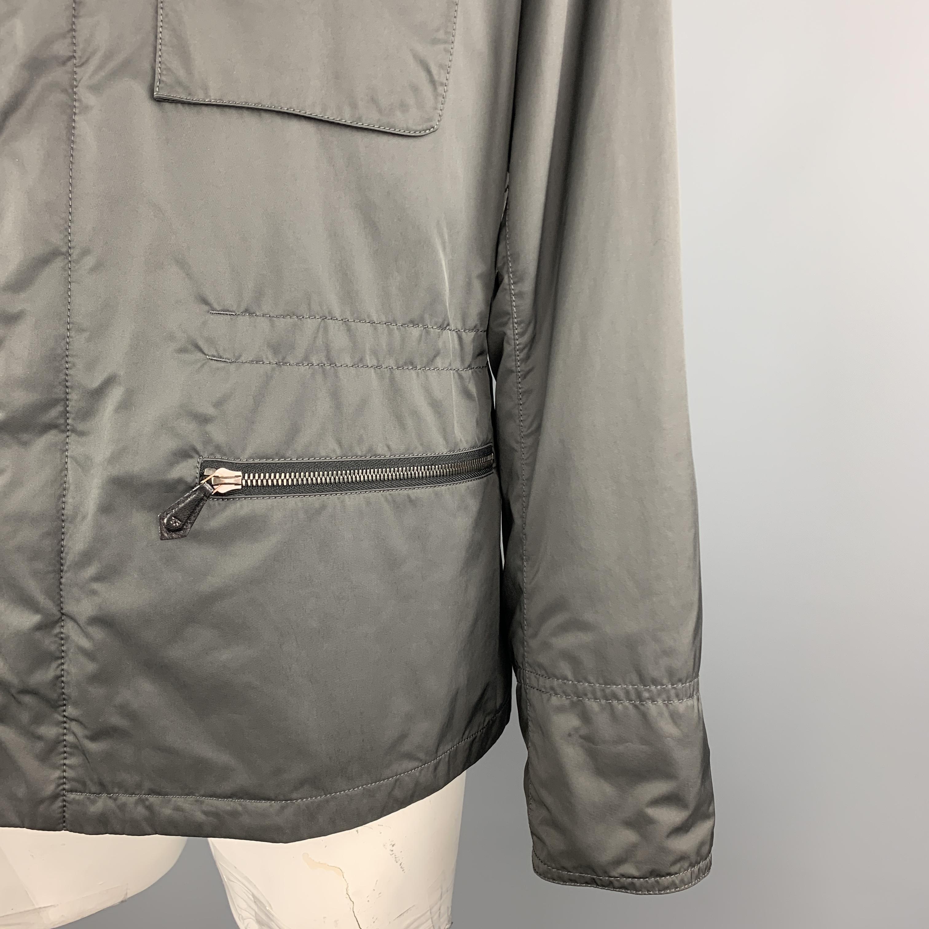 TOM FORD Jacket comes in a gray solid polyester / nylon material, with a high collar, zip and snaps at closure, single breasted, flap and zip pockets, snaps at cuffs, and a inner drawstring at waist. Made in Italy. 

Excellent Pre-Owned