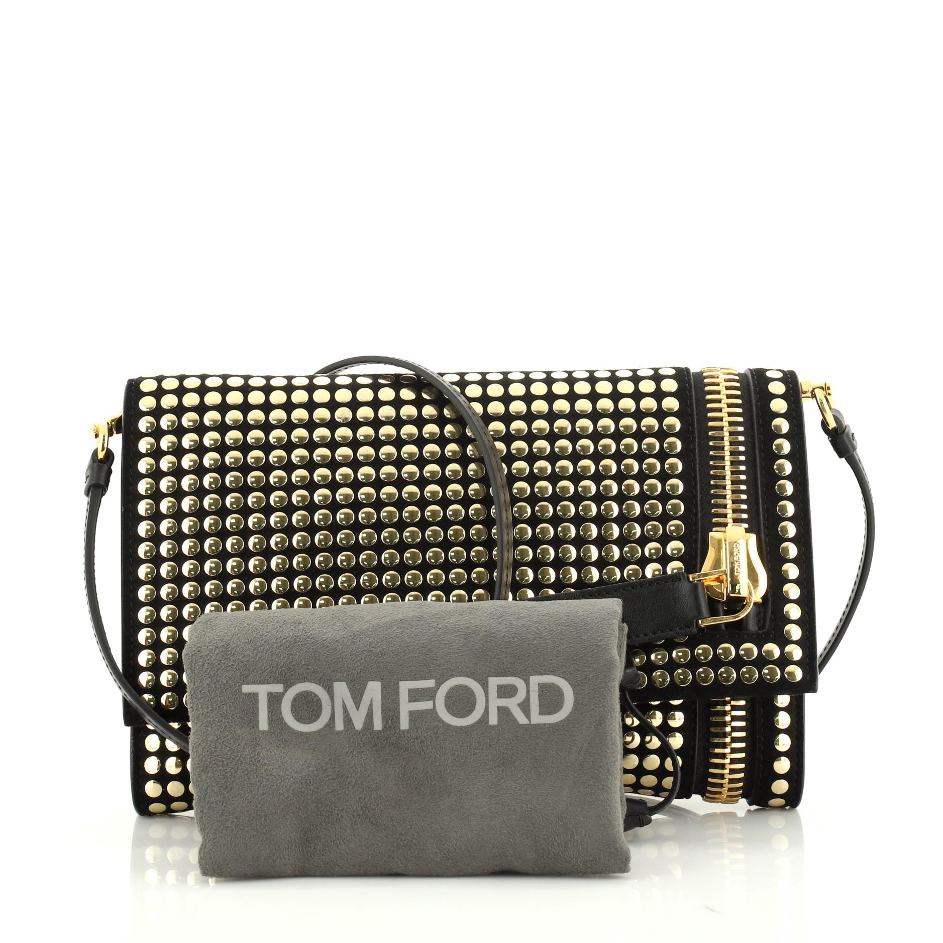 This Tom Ford Alix Fold Over Crossbody Bag Studded Leather Small, crafted from black studded leather, features adjustable leather strap, zipper detail at exterior side, stud embellishments, and gold-tone hardware. Its magnetic snap closure opens to