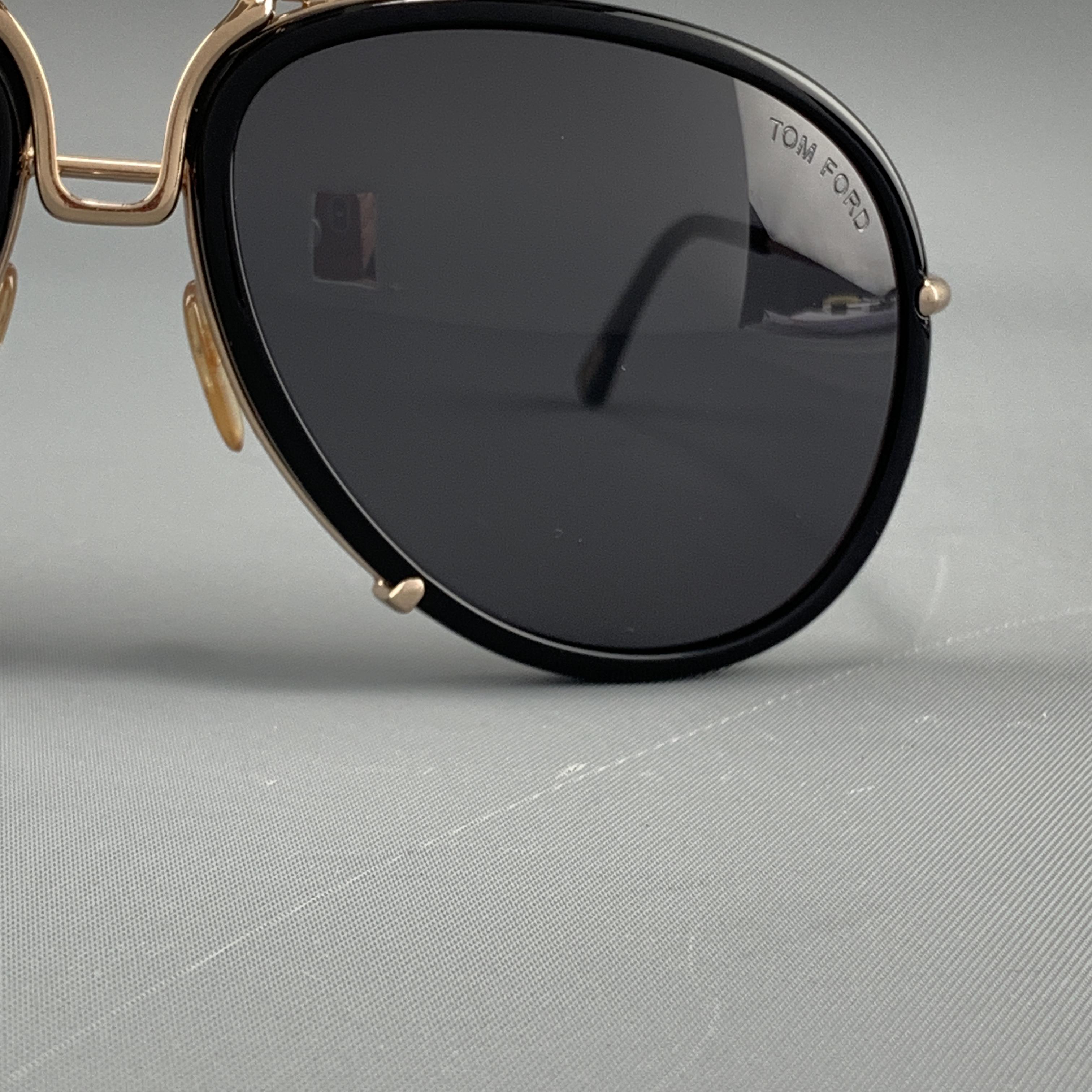TOM FORD Hawkings sunglasses come in gold tone meta with black trimmed aviator lenses. With case and box. Made in Italy.

Excellent Pre-Owned Condition.
Marked: Hawkings TF1 772 63 16 130

Measurements:

Length: 14 cm.
Height: 5.5 cm.
