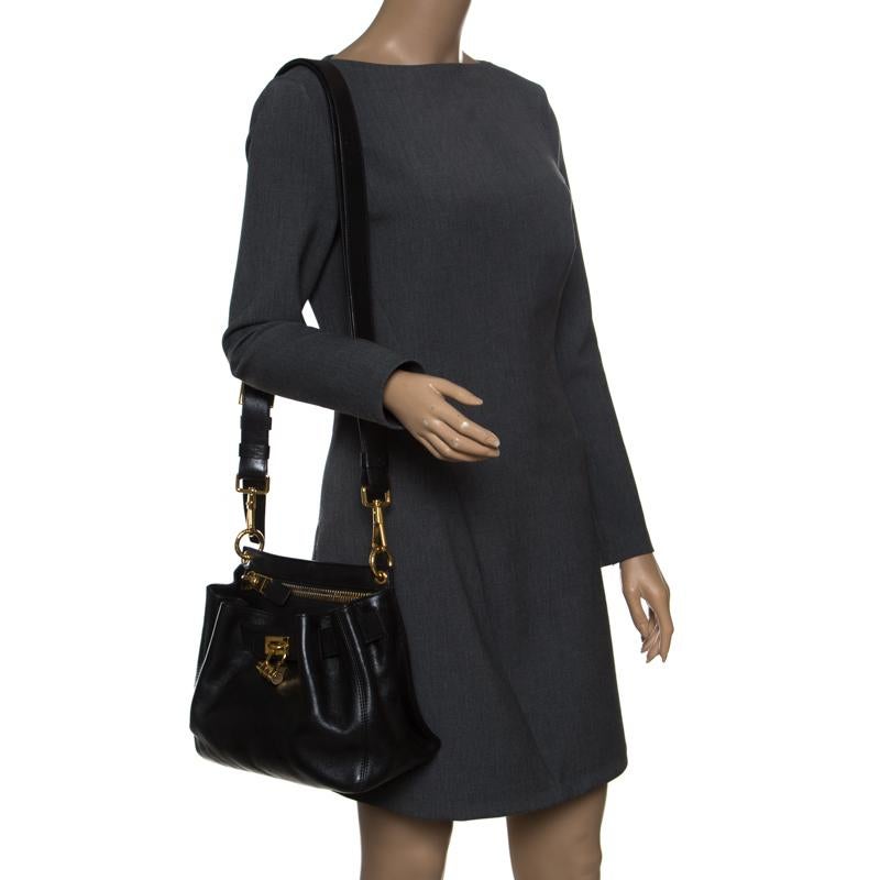 Look exquisite and like you are dressed to kill with this Tom Ford bag. It is beautifully crafted with black leather and feature a belted detail to the front that holds a gold-tone combination lock. The bag opens to divulge a fabric-lined interior