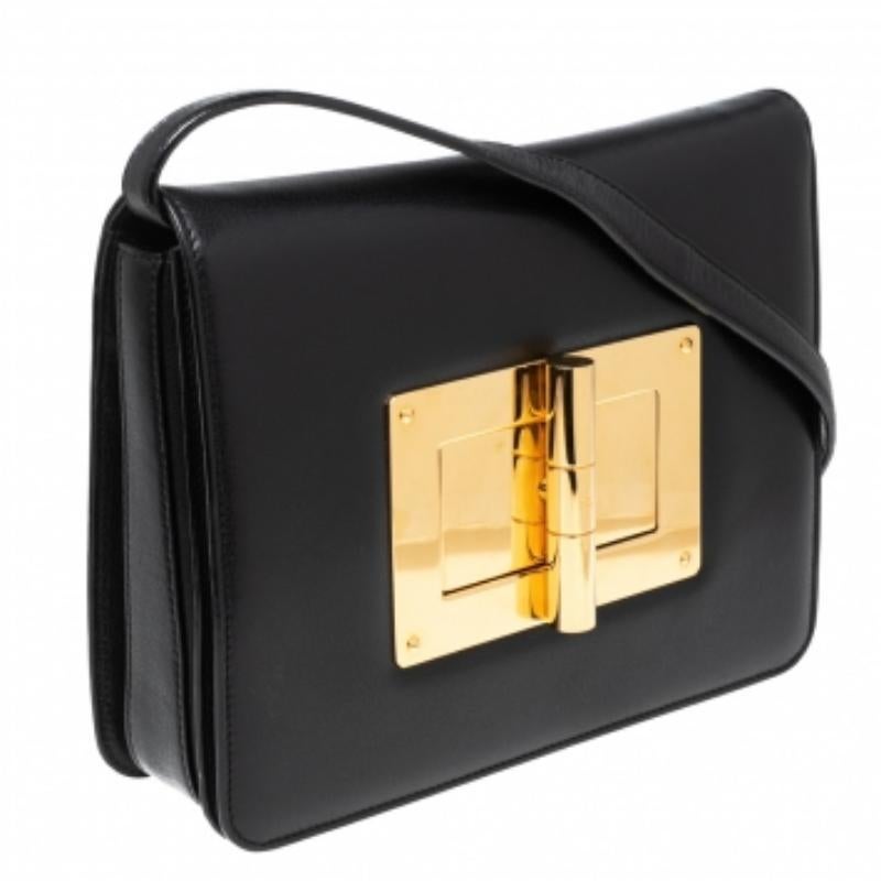 Questa borsa Natalia, firmata dall'omonimo marchio di moda Tom Ford, è stata realizzata con un'abilità e uno stile di alto livello che non ha eguali. È realizzata meticolosamente in pelle nera e presenta una chiusura dorata con le incisioni della