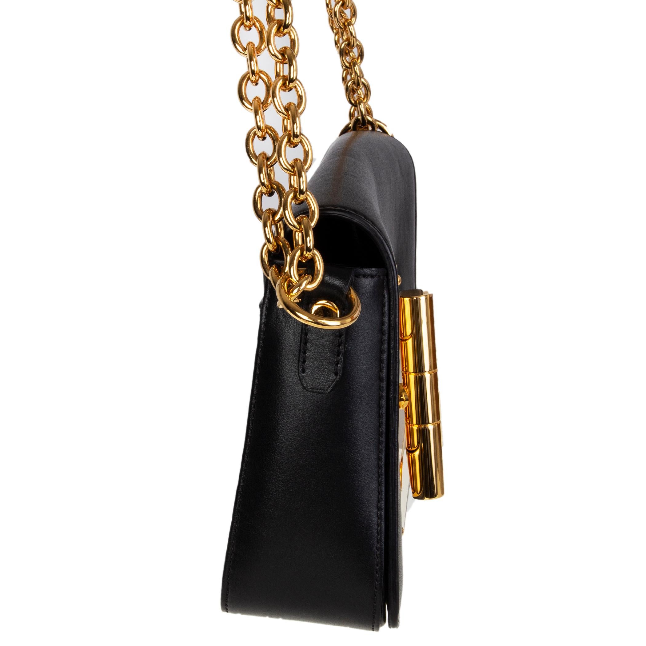 Le sac transversal 'Natalia' de Tom Ford en cuir de veau noir est doté d'un rabat et d'une fermeture tournante surdimensionnée en métal doré. Poche fendue sur le côté arrière. Doublure en microfibre noire avec une poche zippée au dos. A été porté et