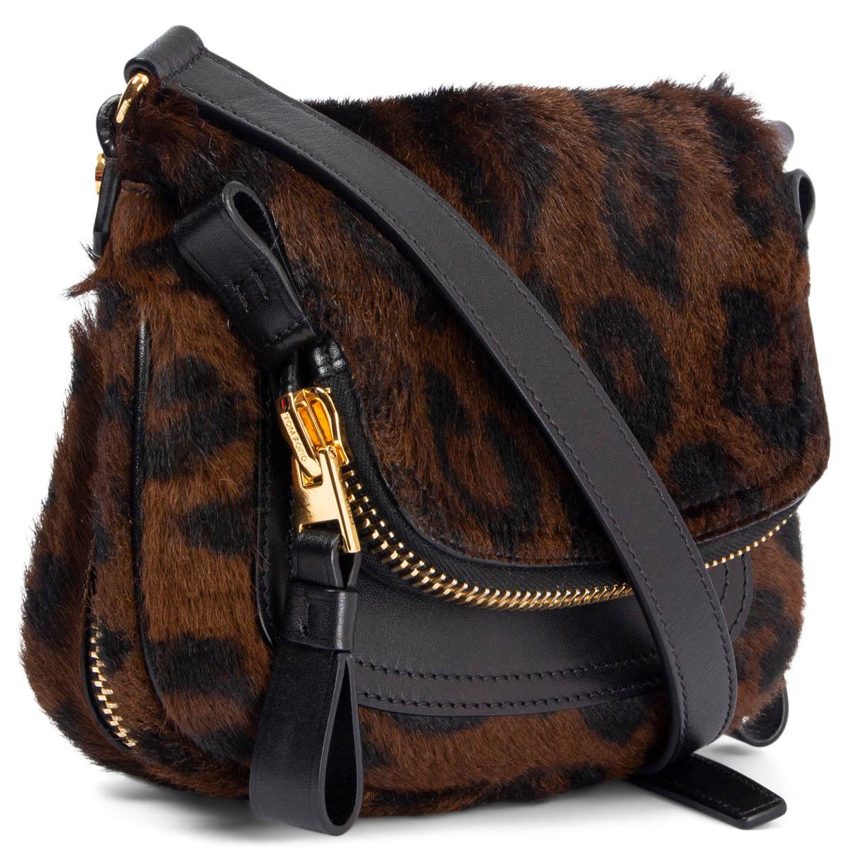 100% authentic Tom Ford Jennifer mini crossbody bag in black and brown printed leopard calf hair and black leather. Adjustable shoulder strap and gold-tone hardware. Expandable zipper gusset on the bottom. Zipper pocket flap with open pocket on the