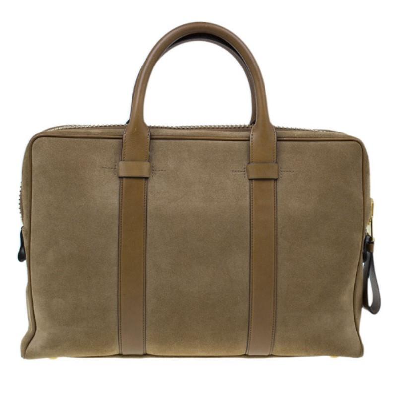 Carry this Tom Ford briefcase for an instantly dapper yet laid back look. Its preppy design is made from light brown suede, completed with a smooth brown leather trim on the front, back, and double top handles. Its top zip closure features golden