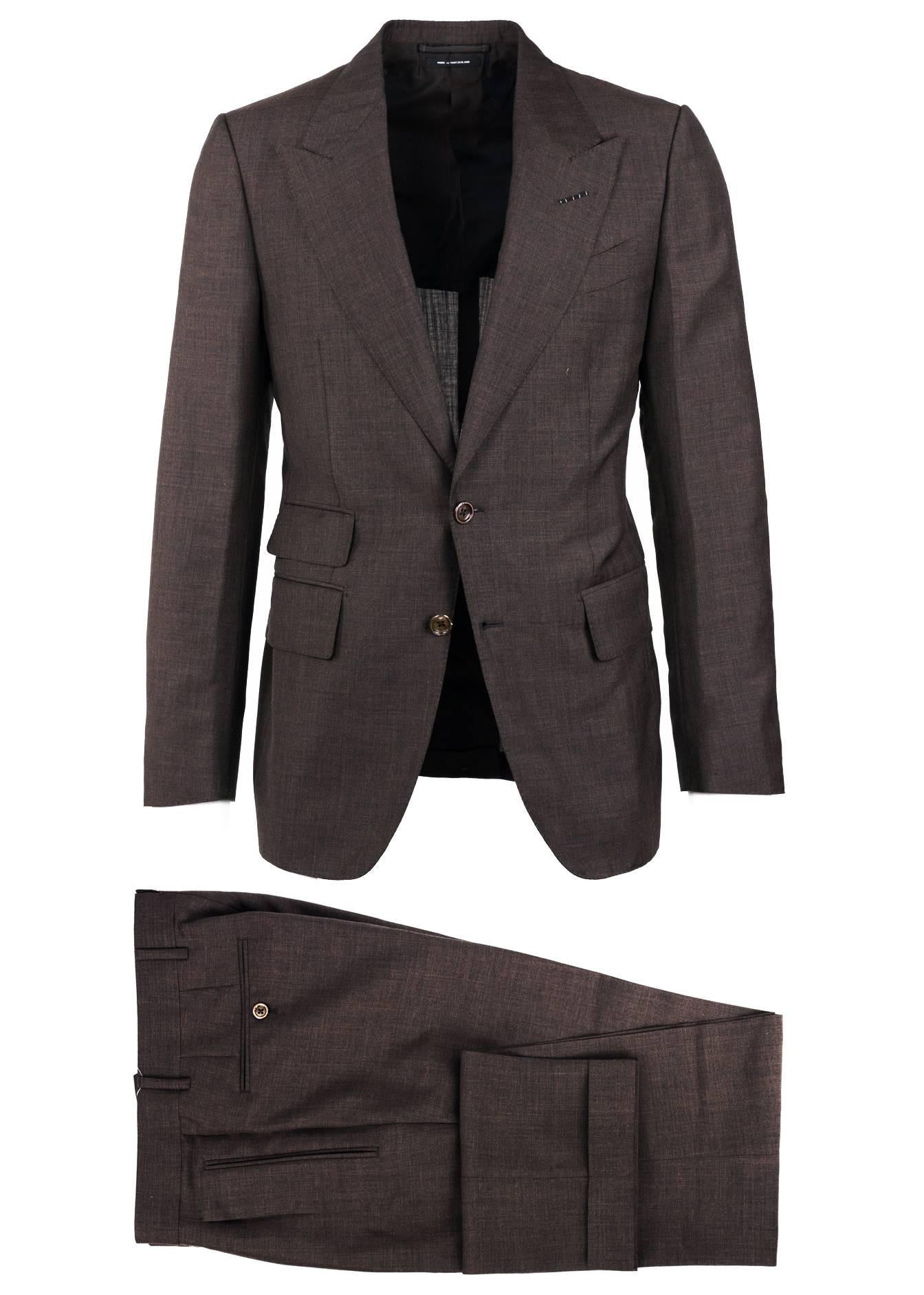 The signature Tom Ford Shelton suit updated in a wool blend textile with a brown undertone color. This constructed Shelton base jacket is finished with notch lapels and flap pockets in a two button silhouette. Dress the suit with a white or black