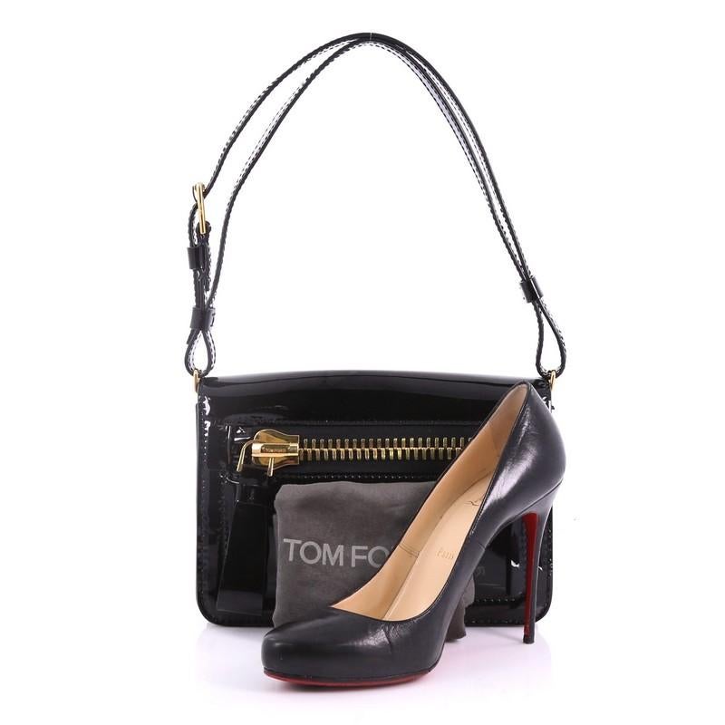 This Tom Ford Buckley Messenger Bag Patent Mini, crafted in black patent leather, features a full frontal flap with exterior zip pocket, adjustable patent leather strap, and gold-tone hardware. Its magnetic snap closure opens to a black leather