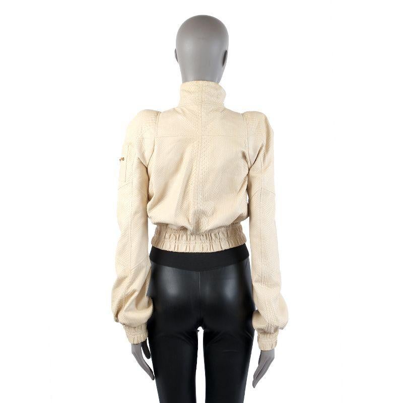 Tom Ford bomber jacket in cream python and gold-tone zippers with shoulder pads. Opens with zipper on the front. Lined in off-white silk (100%). Has been worn and shows some dark makeup stains on the inside and outside edges of the collar. Overall