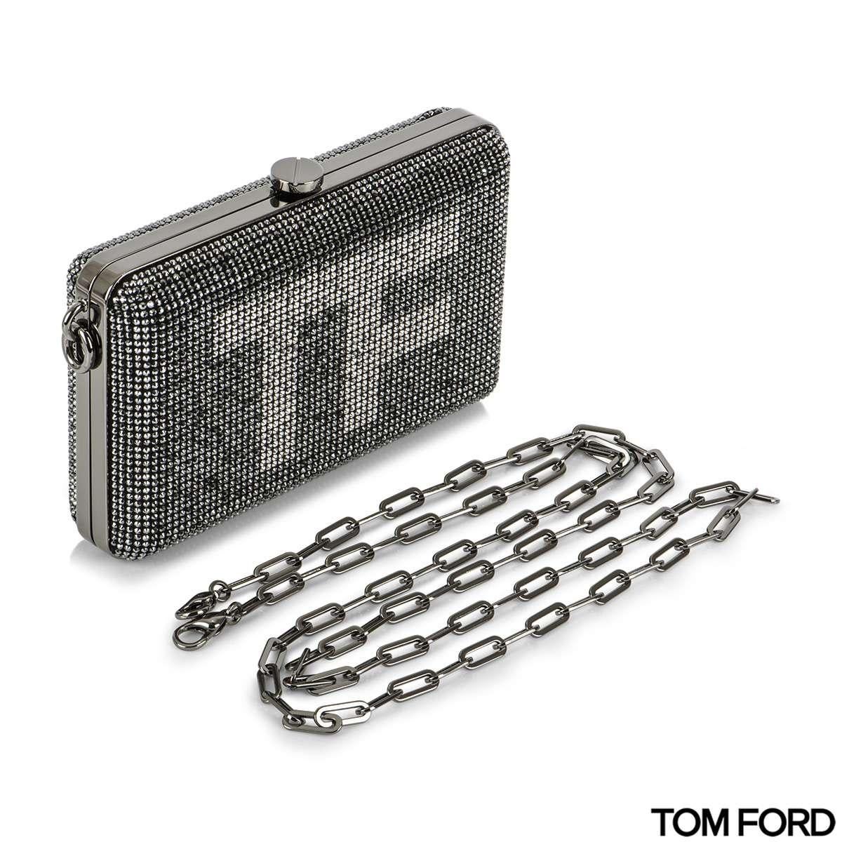 A stunning crystal-embellished mini clutch bag by Tom Ford. This clutch features crystal-embellished soft goatskin leather and contrasting silver-tone crystals with TF design on the front of the clutch. The opening of the clutch is a silver-tone