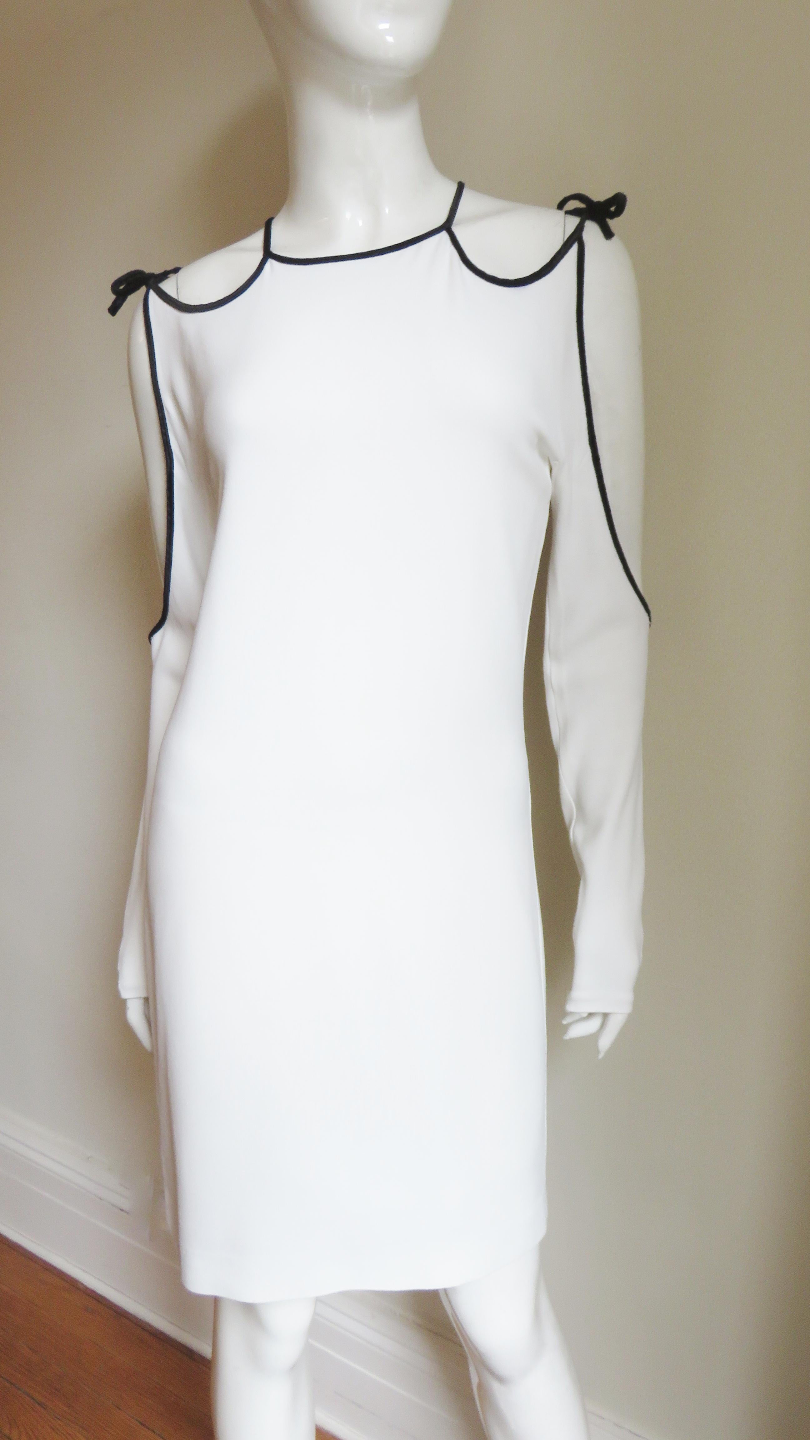 A fabulous white jersey dress from Tom Ford.  It has cut out shoulders, sleeves and back all outlined in black velvet piping which ties at the shoulders.  The dress is semi fitted then falls straight to the hem.  It is unlined, has a hook closing at