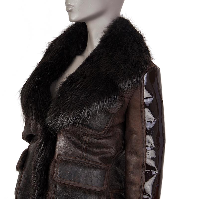 Tom Ford jacket in dark brown leather and patent leahter. With notch collar  hemline and cuffs in black beaver fur, and four shearling flap pockets on the front. Closes with conealed hooks on the front. Lined in dark brown shearling. Has been worn
