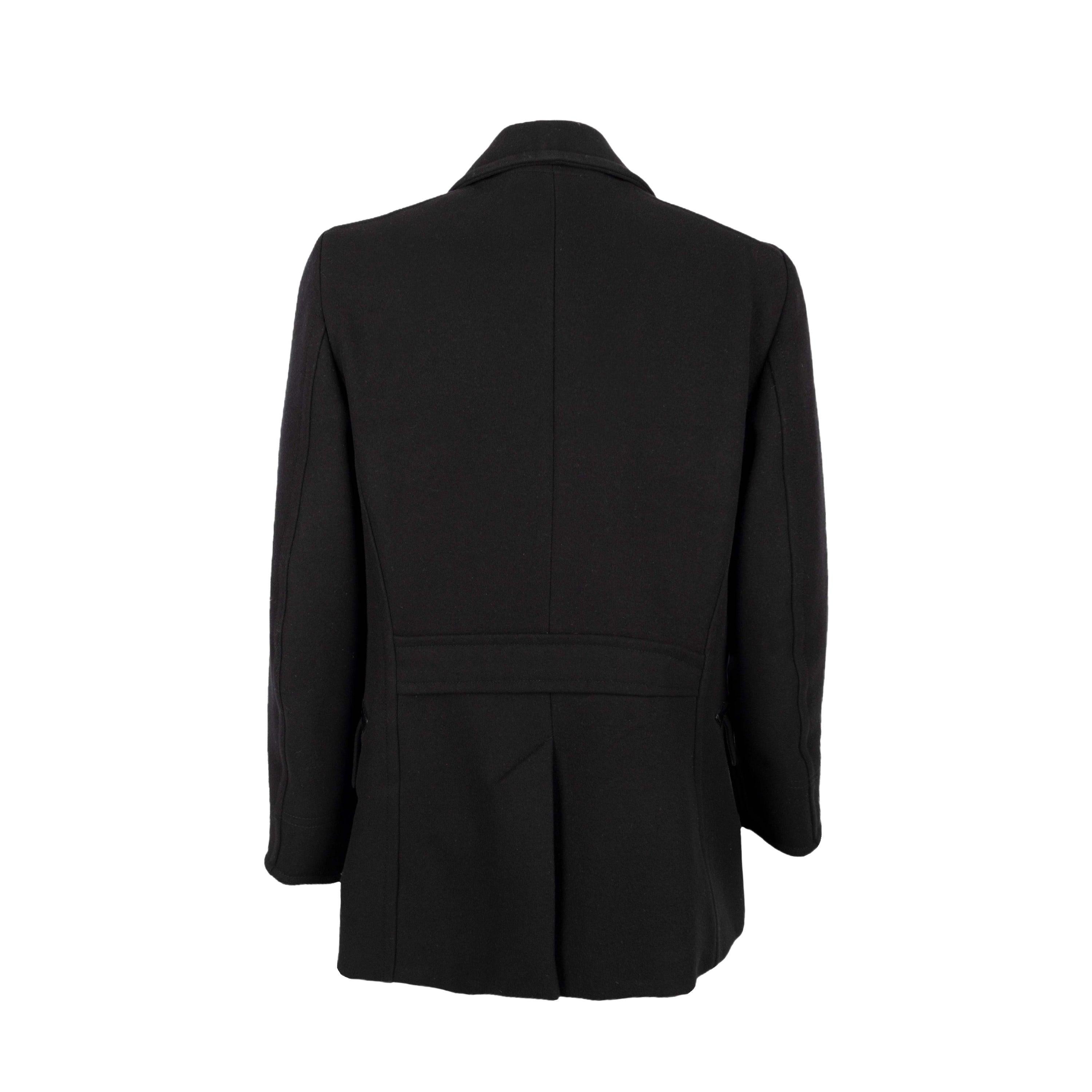 Tom Ford coat in black, featuring a double-breasted design with a lapel collar. It has two vertical pockets with leather piping, a unique and elegant detail that adds a touch of luxury to the jacket and two pockets with flaps.
 The jacket has a