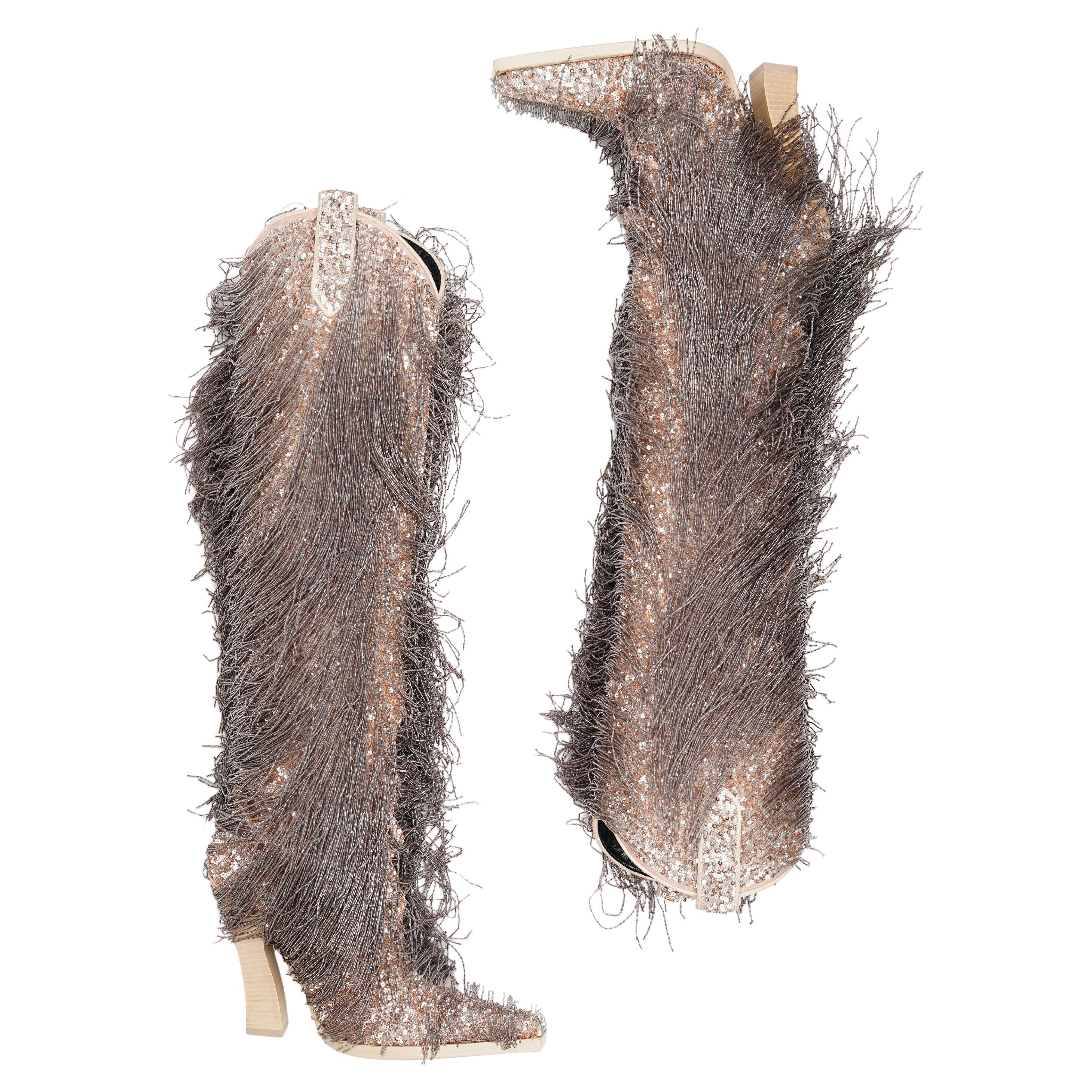 Paire éblouissante et rare issue de la collection automne/hiver 2020 de Tom Ford, ces bottes à hauteur de genou illustrent le mélange de glamour, d'artisanat audacieux et de sensualité moderne propre au créateur.
Méticuleusement ornées à la main de
