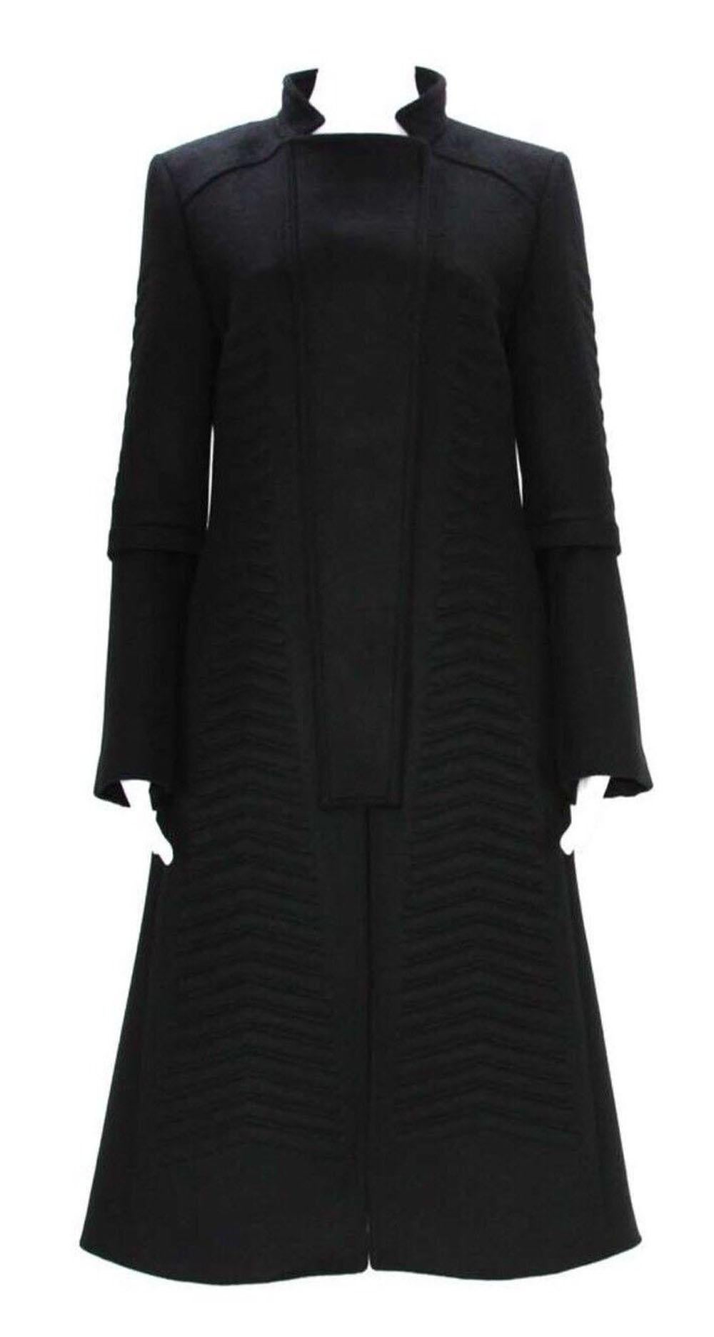 Manteau noir Tom Ford pour Gucci avec ceinture
Collection F/W 2004
Laine angora noire, matelassé en motif chevron, double boutonnage, fermeture par boutons-pression, poches latérales. 
Manches cloche avec fermeture éclair, entièrement doublée,