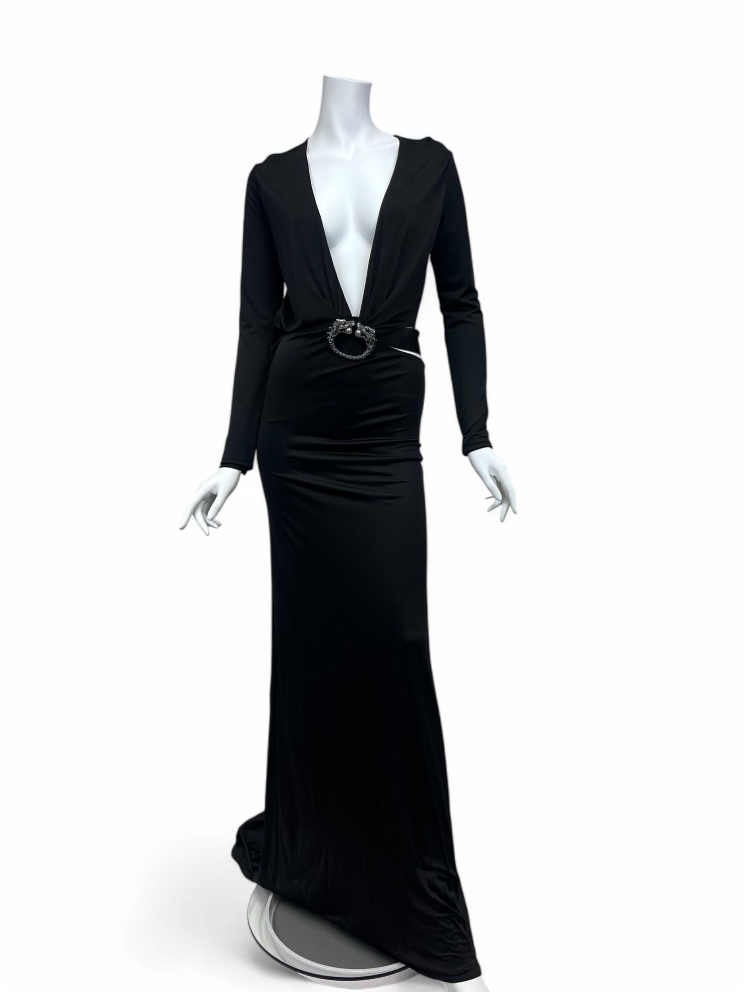 An iconic creation from Tom Ford’s final collection for Gucci, this Fall/Winter 2004 black evening gown embodies seductive glamour and impeccable craftsmanship. Designed with a deep plunging neckline and dramatic waist cutouts, the silhouette is