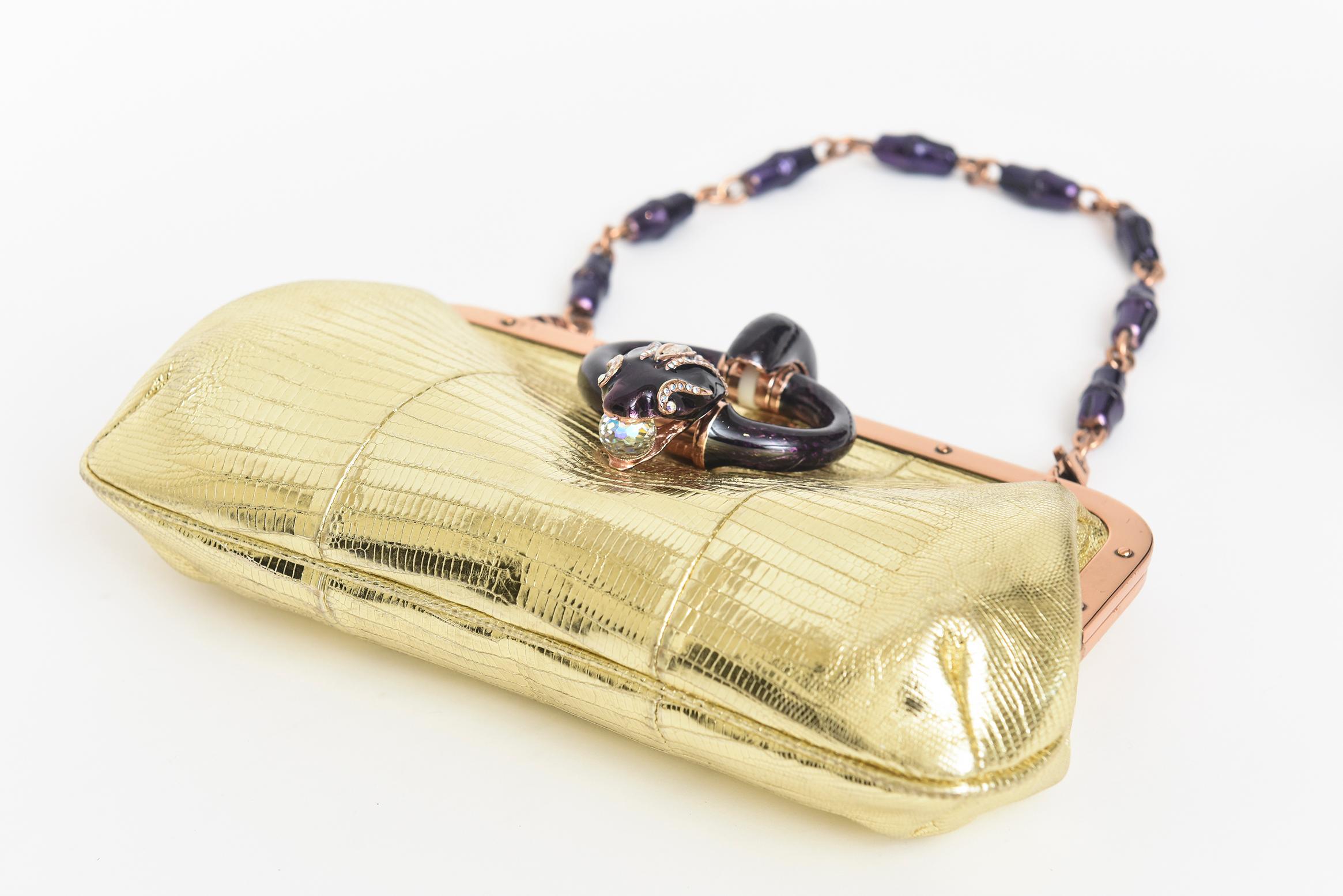 This beyond stunning and now rare evening bag was Tom Fords serpent final Collection for Gucci in 2004. It was a limited edition and a runway piece. It is gold lizard leather with rose gold trimming and amethyst serpent closure. The removable handle