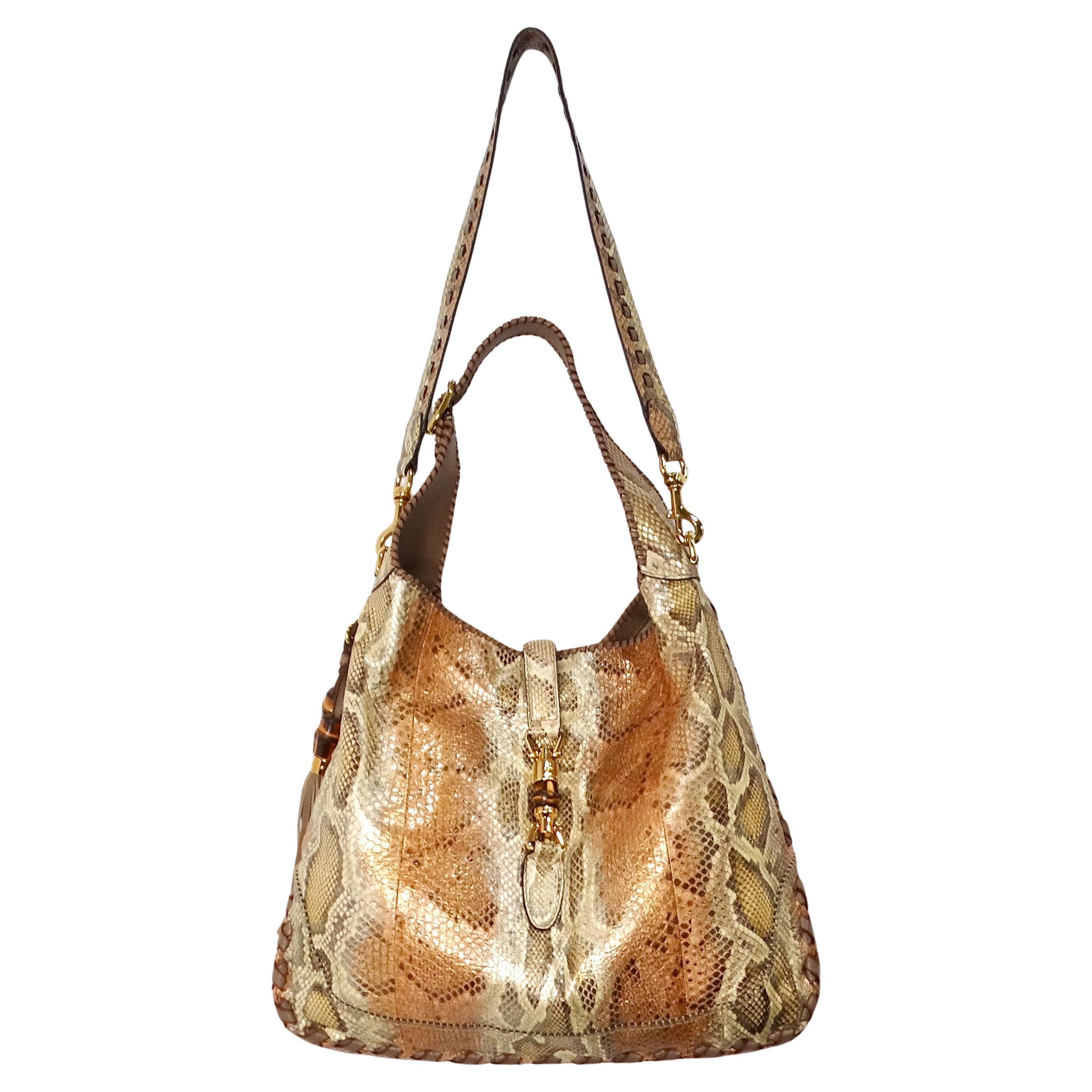 The Tom Ford for Gucci Large Iridescent Python Jackie Hobo Bag from the circa 1990s is a stunning example of luxury craftsmanship and timeless design. Crafted from exquisite iridescent python leather, this bag exudes an opulent and sophisticated