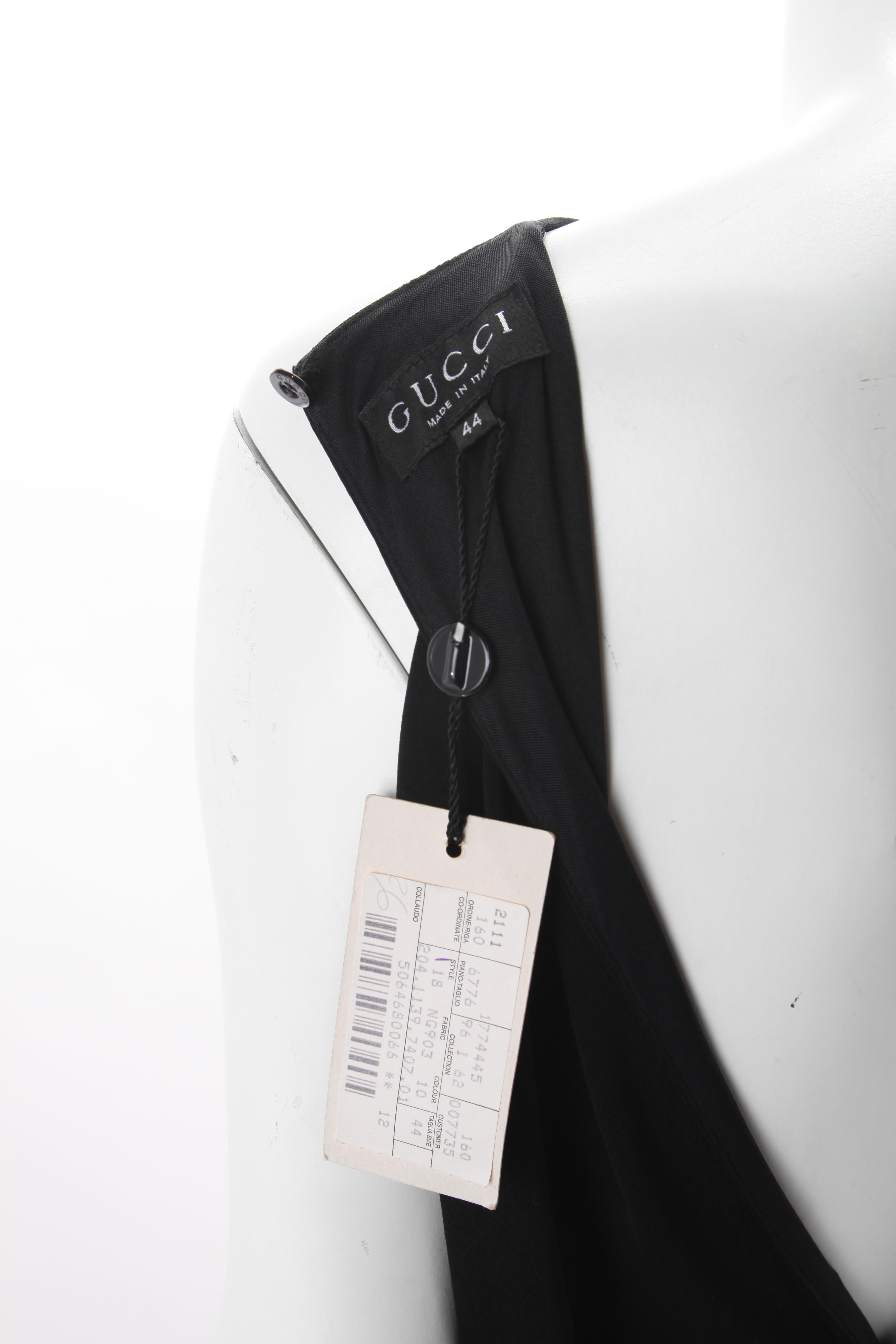 Tom Ford for Gucci Long Black Jersey Dress with Gold Belt. 1996.
Long spaghetti strap black jersey dress featuring detachable black belt with circular metal gold hardware. Back bodice features a cut out back with button fastening at the neck. Belt