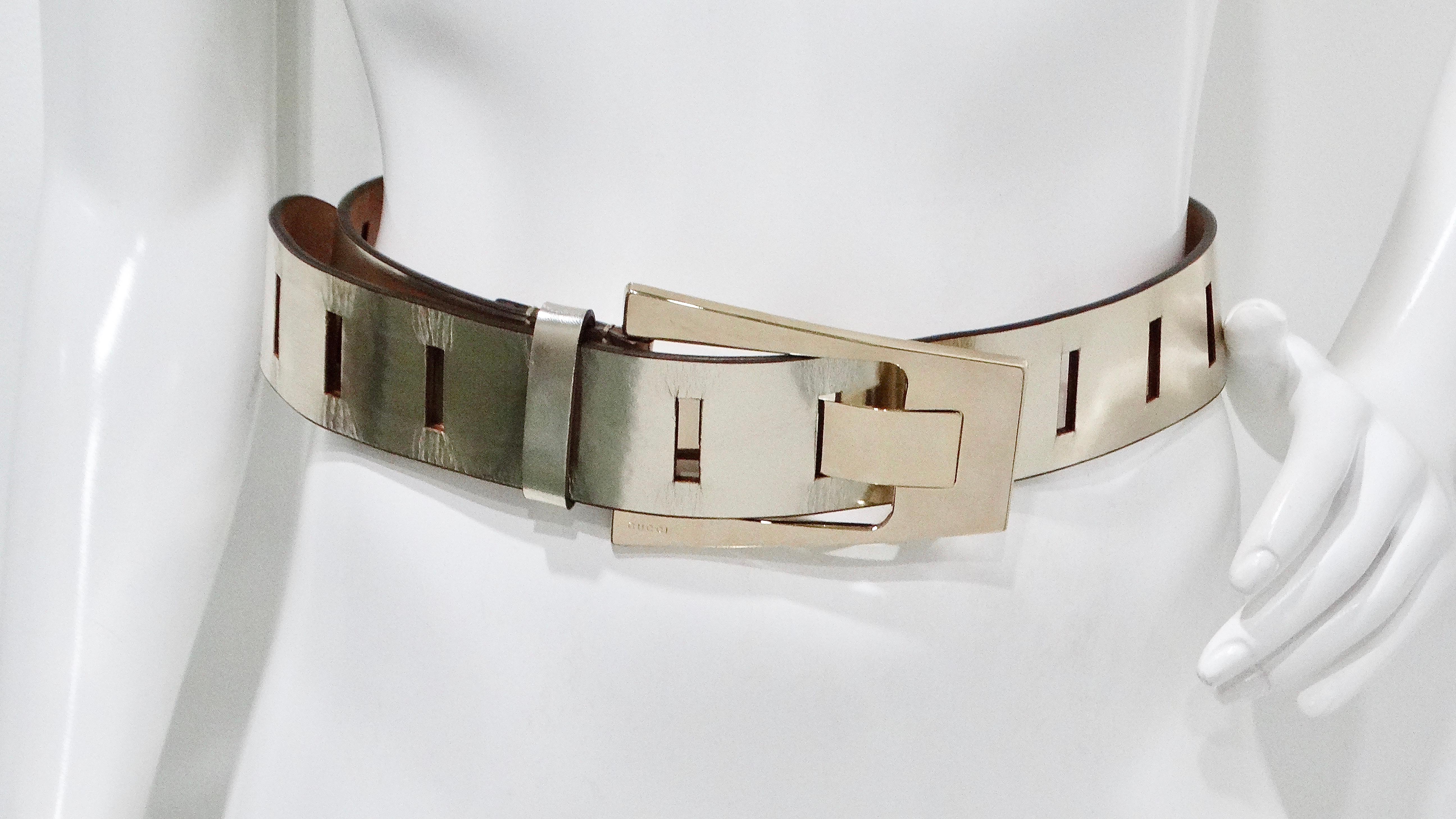 The Tom Ford for Gucci leather metallic belt is a striking statement piece that exudes luxury and sophistication. Crafted in a light champagne color, this wide, chunky belt features a fun and eye-catching metallic buckle that instantly elevates any