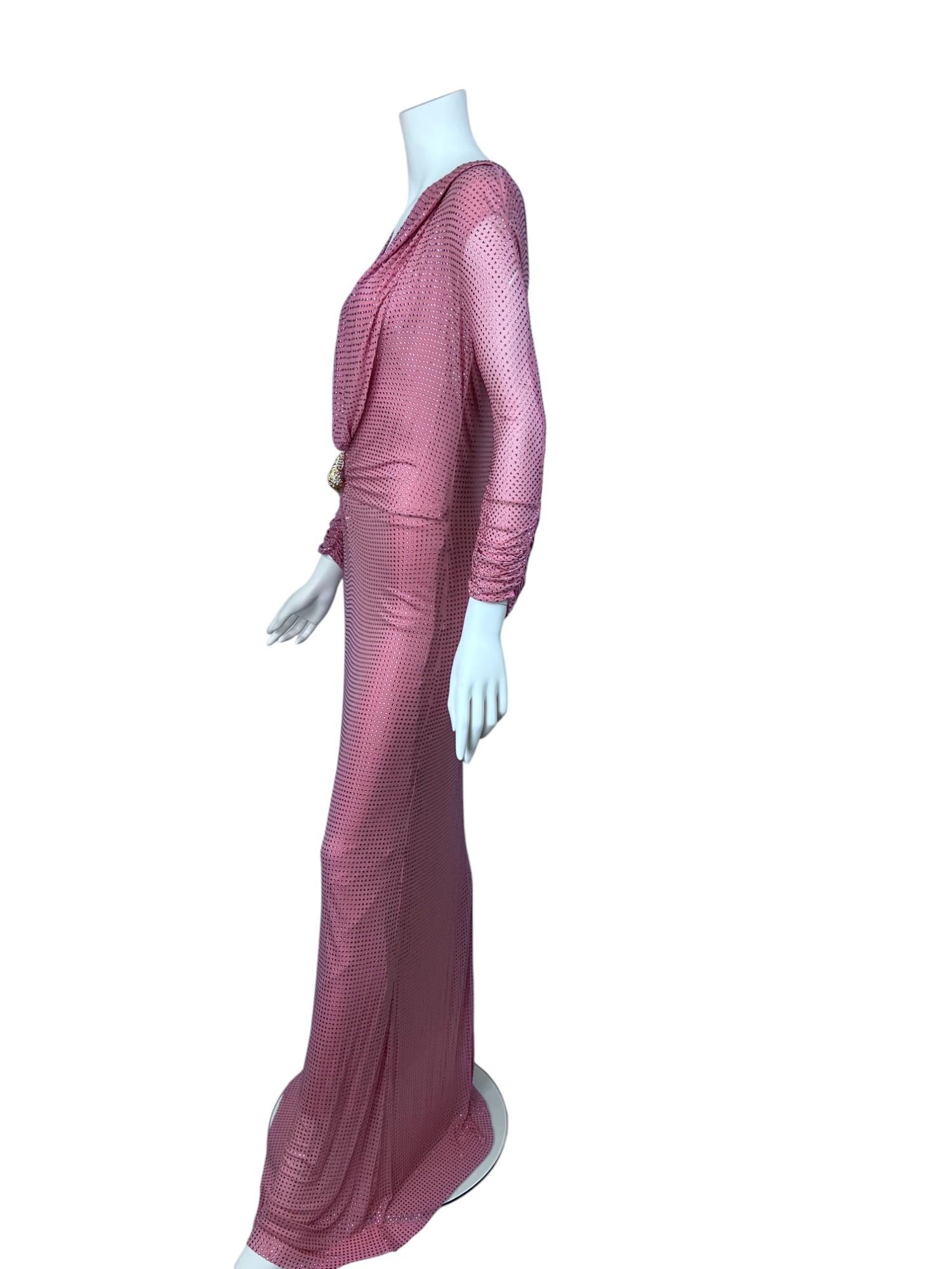 Este vestido rosa adornado con cristales, una creación excepcional y espectacular de la etapa de Tom Ford en Gucci, es el epítome del lujo y la sensualidad. Confeccionado en un tejido ceñido con incrustaciones de brillantes cristales rosas, el