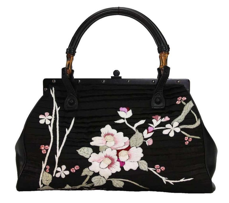 Tom Ford For Gucci Black Silk Frame Japanese Flowers Bag
S/S 2003 Collection
N 112528 204990
Rare And Collectible
Color – Black; Silk, Leather, Bamboo; Floral Japanese Embroidery In White, Pink, Red, Green On Both Sides
Leather Side Panes,