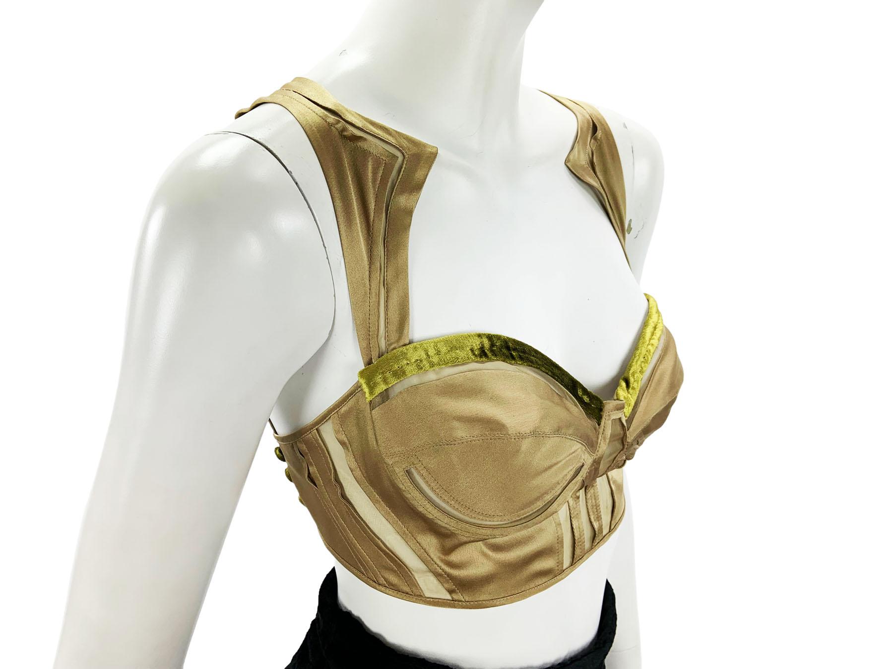 Tom Ford for Gucci - Bustier Crop Top
Taglia italiana - 42
Collezione 2004
Composizione: 85% seta, 15% elastan. 
Il colore bronzo chiaro si sposa con il velluto giallo  Accenti. 
Bottoni decorativi in velluto giallo, reggiseno con ferretto, spalline