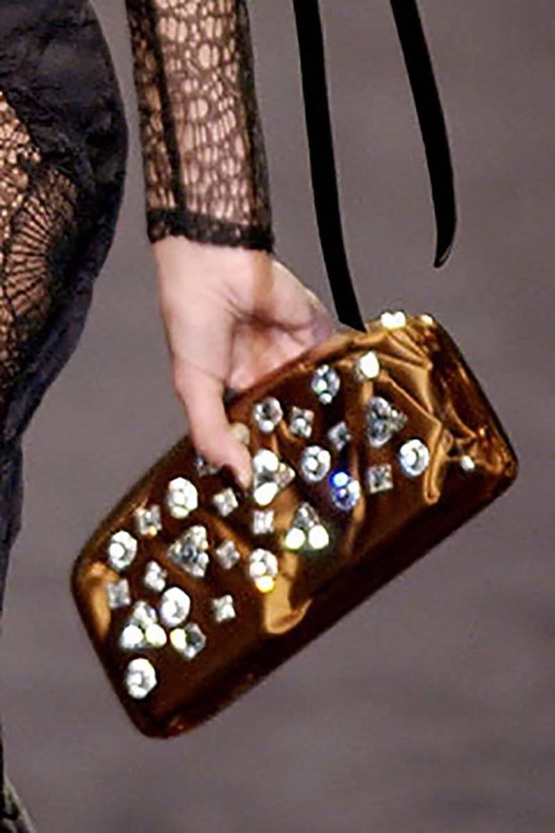 Tom Ford for Yves Saint Laurent 
Collezione 2003
Pochette in PVC Jewell e impreziosita
Sottostrato e fodera in raso marrone.
Chiusura Kiss-lock. Ferramenta in tonalità argento.
Misure: 10 pollici x 4,5 pollici
Peso - 1,14 lb
Prodotto in