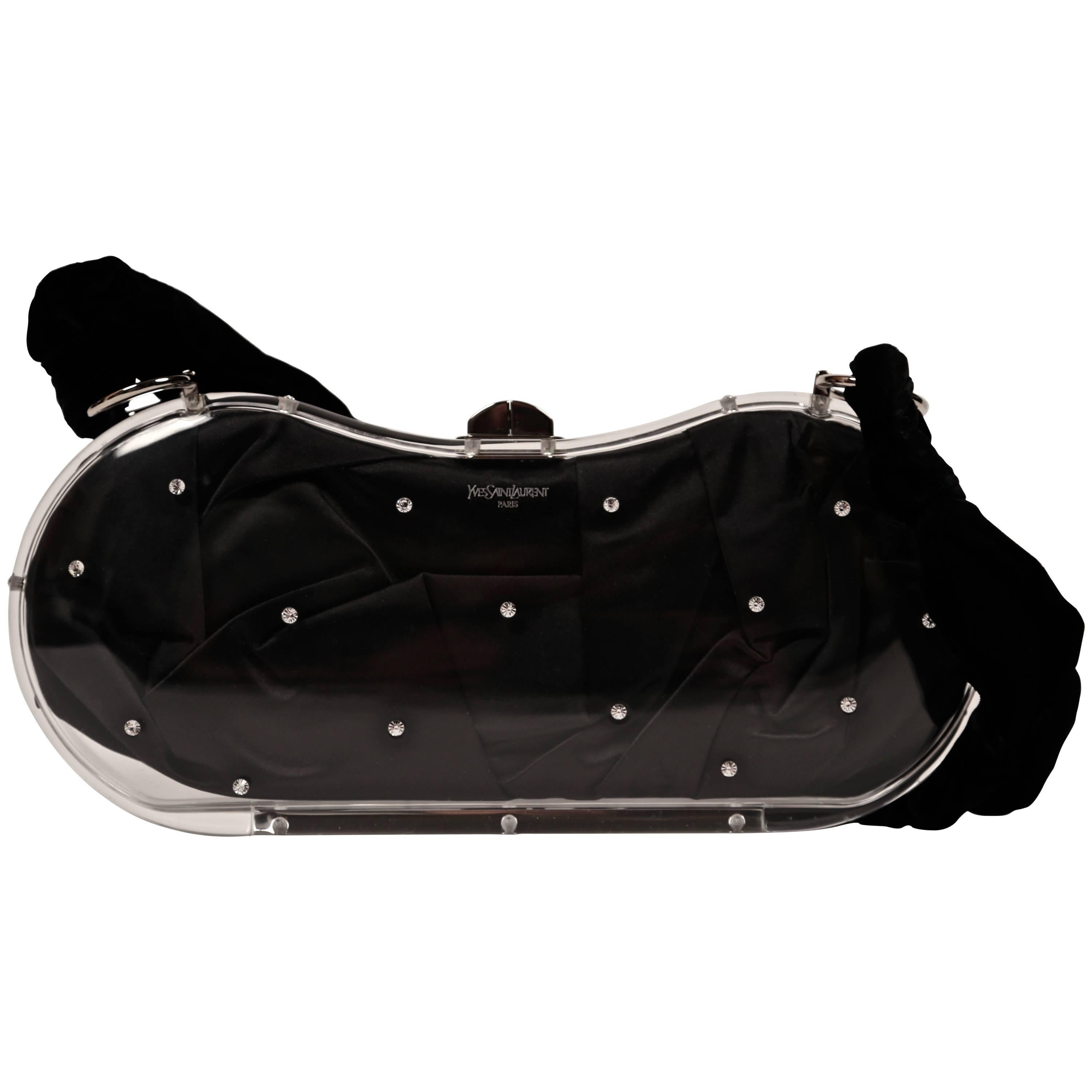 Very rare clear lucite evening bag with rhinestones lined in black satin with black velvet strap designed by Tom Ford for Yves Saint Laurent dating to Fall 2003. Bag measures just over 11