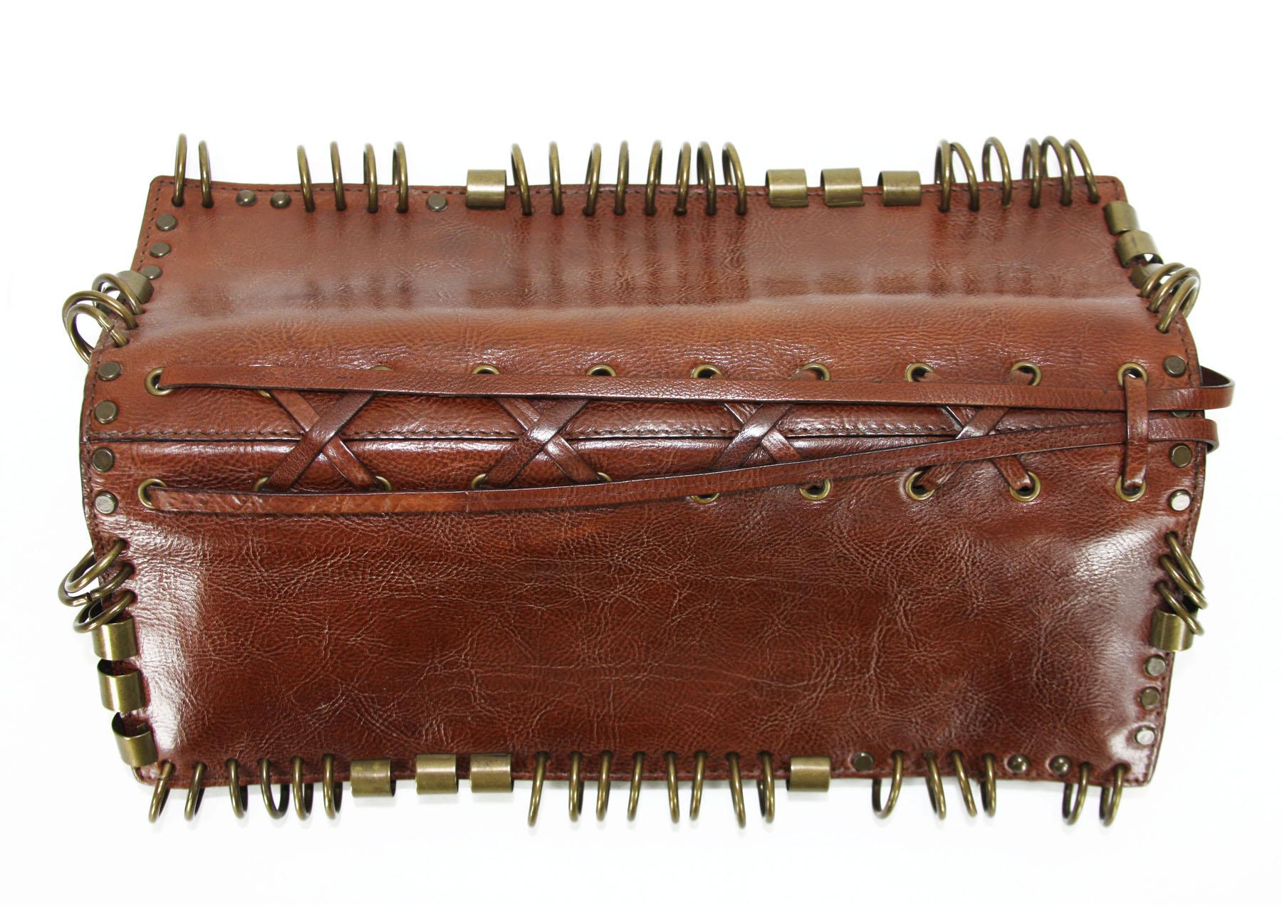 Very rare ring-studded leather clutch designed by Tom Ford for Yves Saint Laurent Rive Gauche.
Spring/Summer 2002 Ready-to-Wear Collection.
Cognac color.
Measurements: L - 10.5 inches, H - 4 inches.
N 95927-001998
Long leather strings to wrap around