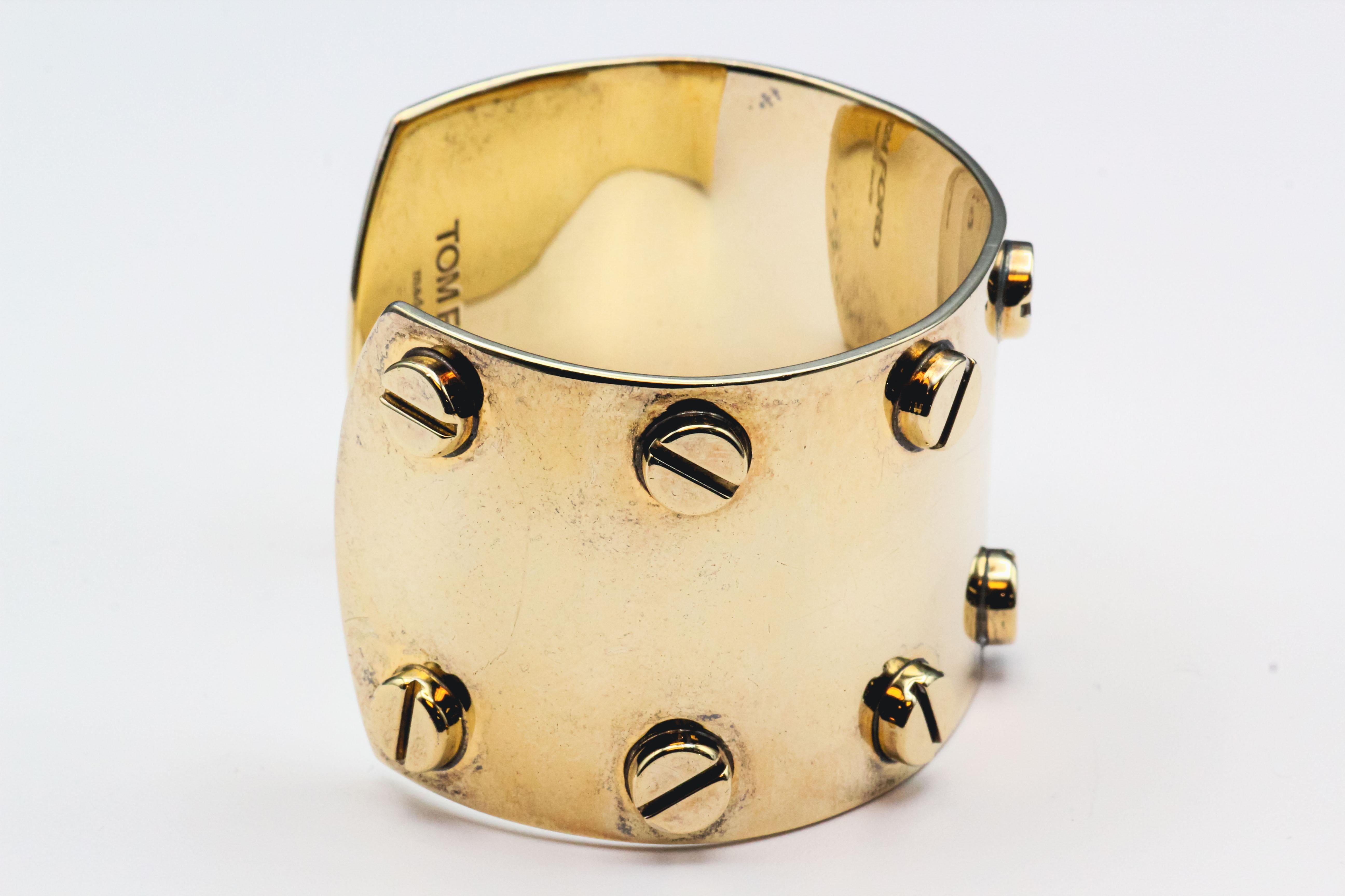 Elevate your style with the bold and edgy elegance of the Tom Ford gold-plated silver screw cuff bracelet. Designed to make a statement, this piece exudes a sense of modern luxury and sophistication.

Crafted from high-quality silver and plated with