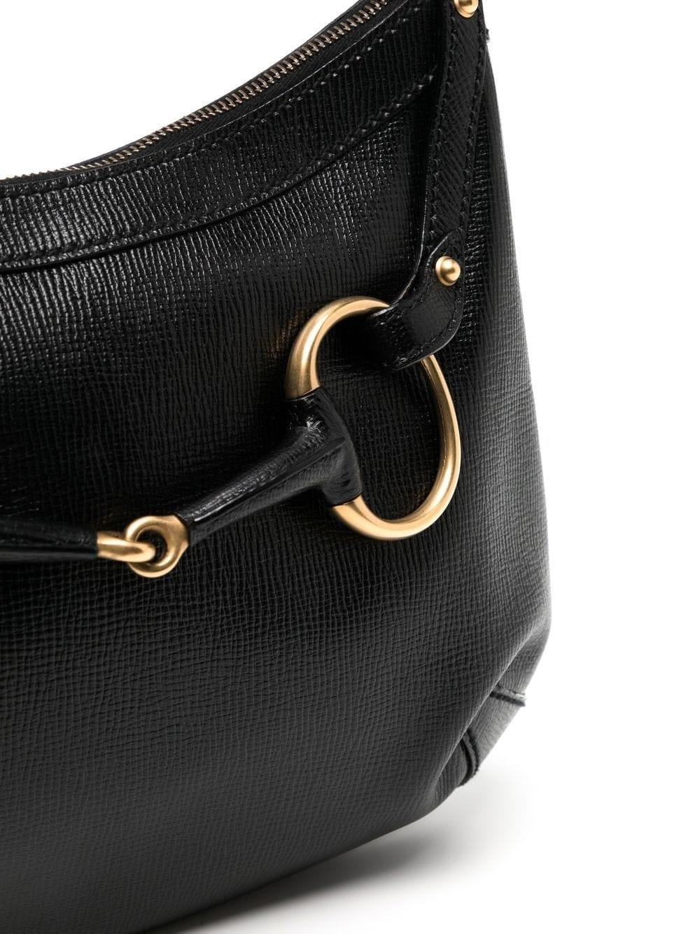From Tom Ford's era at Gucci, we present a piece showcasing his interpretation of the iconic Jackie bag. With gold-tone hardware and black-grain leather, this shoulder bag is sleek and sexy. 