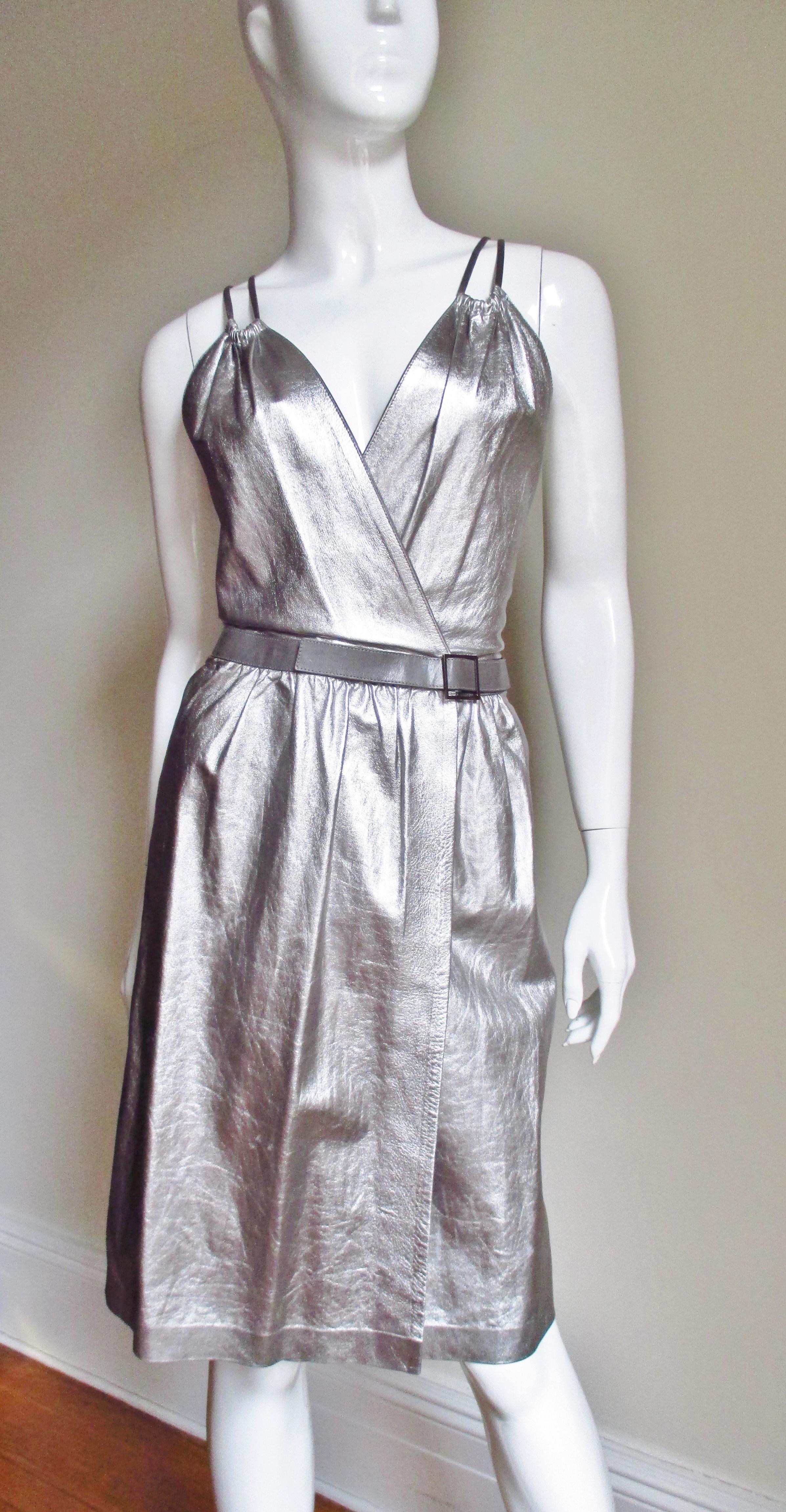 A beautiful silver leather wrap dress by Tom Ford for Gucci . The bodice crosses in the front wrapping at the waist and closing with snaps.  It has a fine grey leather belt matching the shoulder straps which extend from the front and cross in the