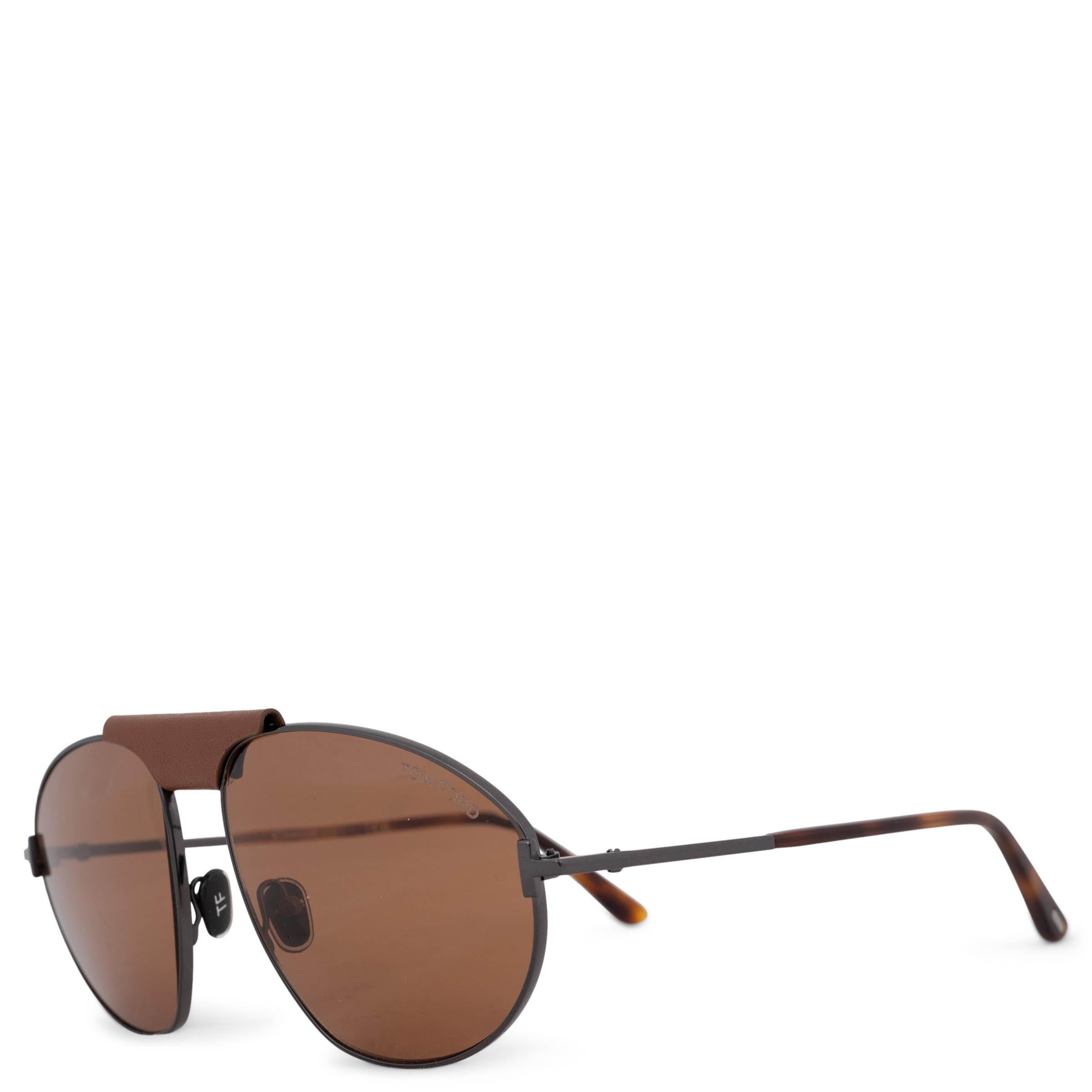 Diese 100% authentische Tom Ford Ken Sonnenbrille in glänzendem Gunmetal verkörpert klassisches Aviator-Styling mit einem luxuriösen Twist. Mit ihren braunen Gläsern, einem raffinierten braunen Ledersteg und schildpattfarbenen Bügelenden verbindet