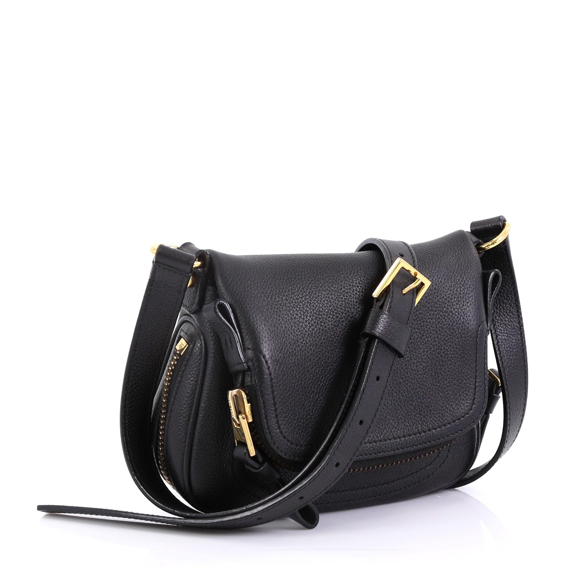 This Tom Ford Jennifer Crossbody Bag Leather Mini, crafted in black leather, features an adjustable crossbody strap, zip-top fold-over flap, and gold-toned hardware. Its zip closure opens to a black microfiber interior with side zip