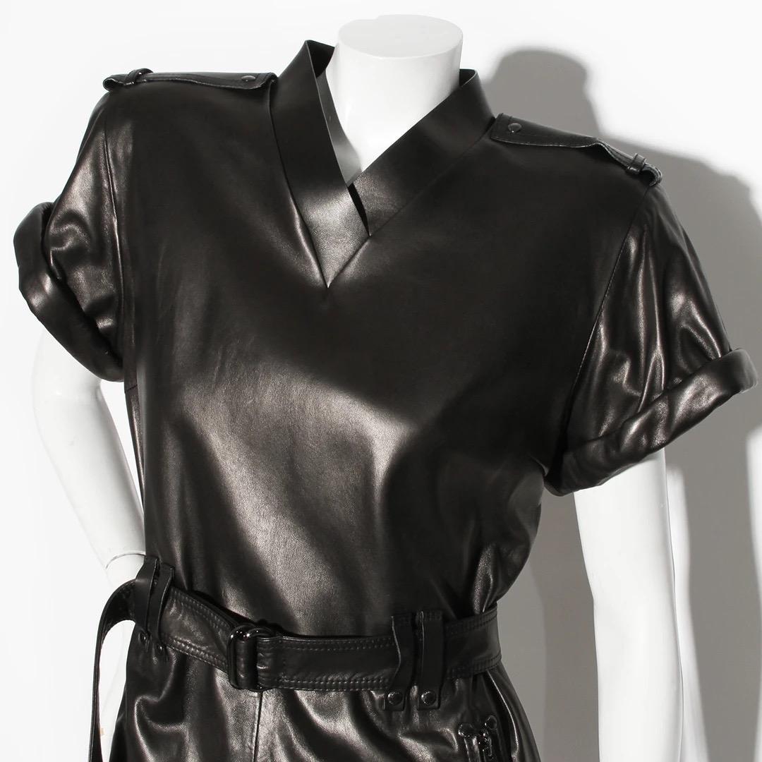Tom Ford Leather Mini Dress
Made in Italy 
Black leather 
V-neckline
Rolled cuff on sleeves
Double ring belt around waist with belt loops
Padded shoulders with epaulettes
Back zip closure
Two zip pockets at the hips
One open pocket on bottom left