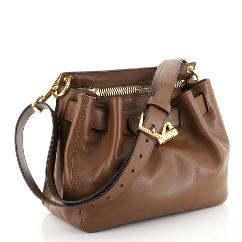 This Tom Ford Lock Front Crossbody Bag Leather Small, crafted in brown leather, features adjustable leather strap, belted front compartment with padlock closure, zip compartment, and gold-tone hardware. It opens to a brown microfiber interior.