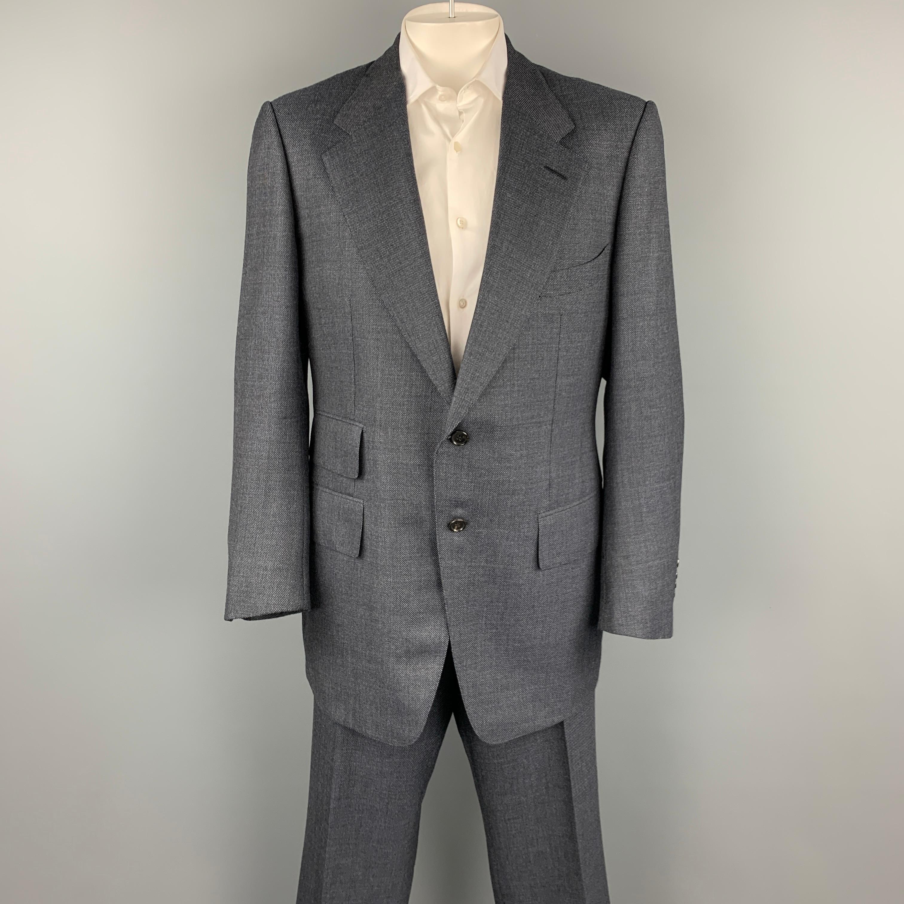 TOM FORD suit comes in a navy wool / silk with a full liner and includes a single breasted, two button sport coat with a notch lapel and matching cuffed flat front trousers.

Very Good Pre-Owned Condition.
Marked: 58