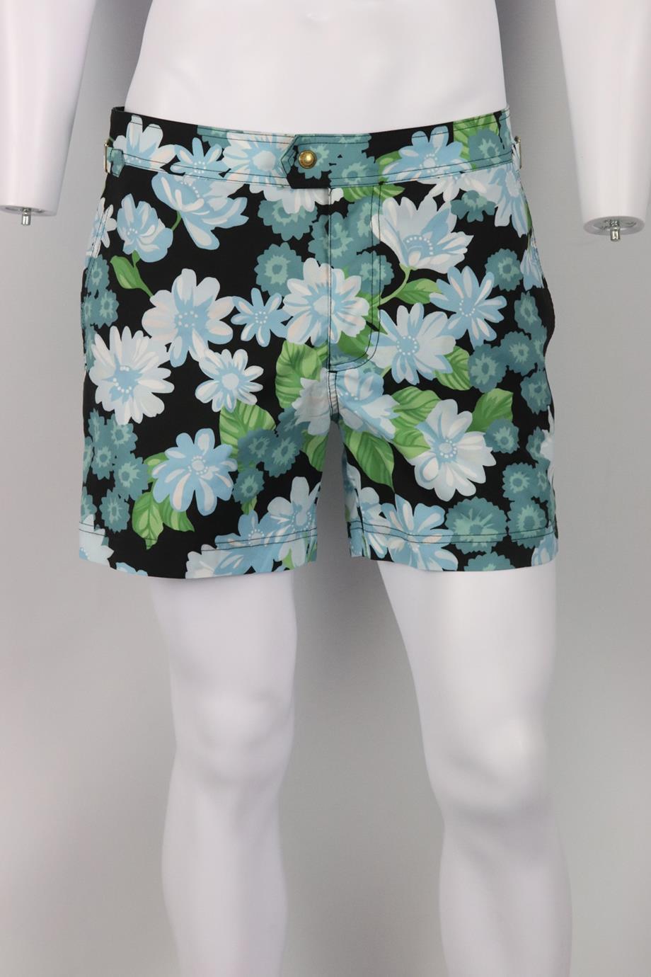 Tom Ford men's floral print shell swim shorts. Blue, green, white and black. Hook, eye and zip fastening at front. 100% Polyester. Size: IT 48 (Medium, UK/US Waist 32). Waist: 33.6 in. Hips: 41 in. Length: 16 in. Inseam: 4.9 in. Rise: 10.6 in. Very