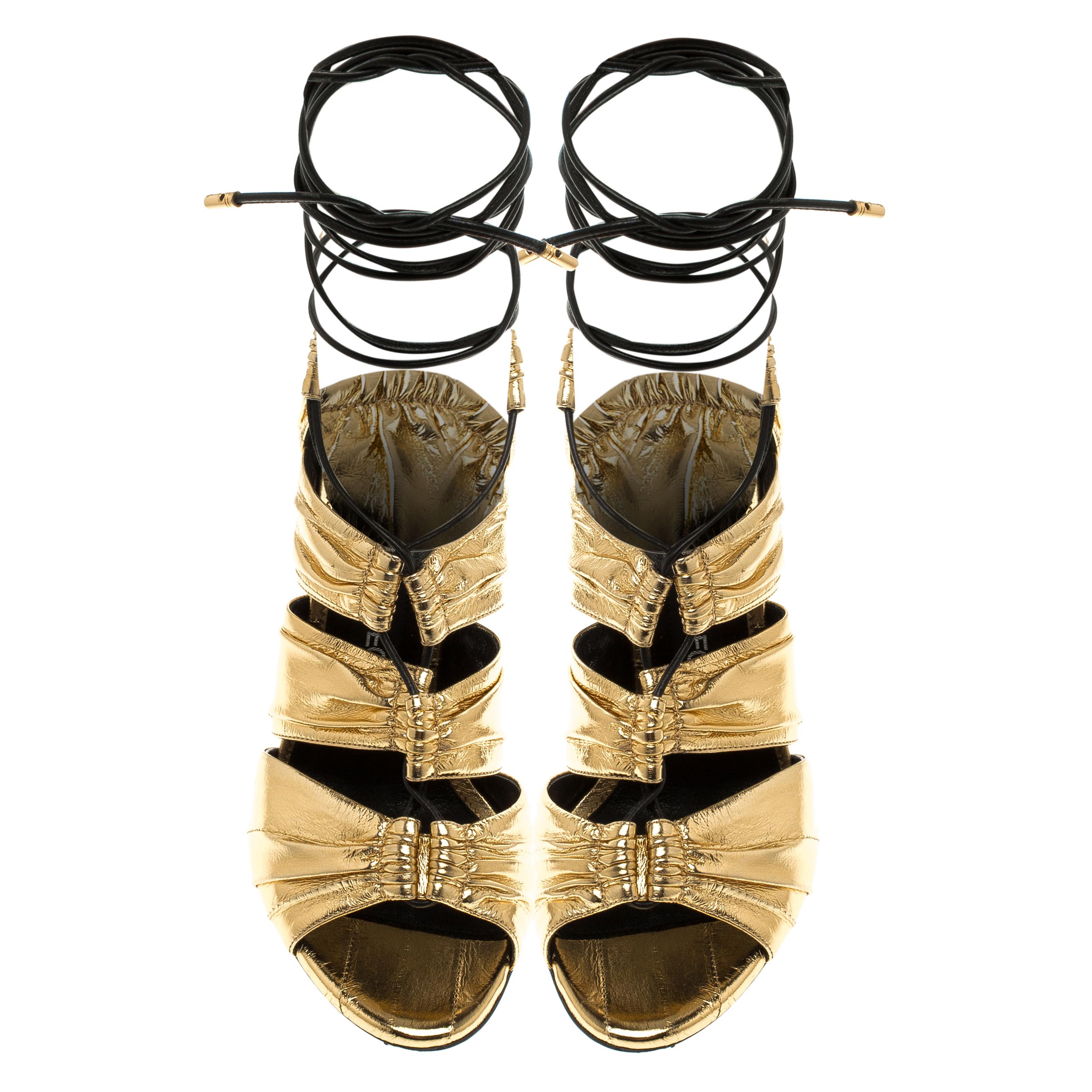 Crafted exquisitely from gold leather in cutouts and ruched design, these Tom Ford sandals were built to lift your outfits and your spirits. Leather strings are laced perfectly at the front, ending as ties around the ankle while beautifully sculpted